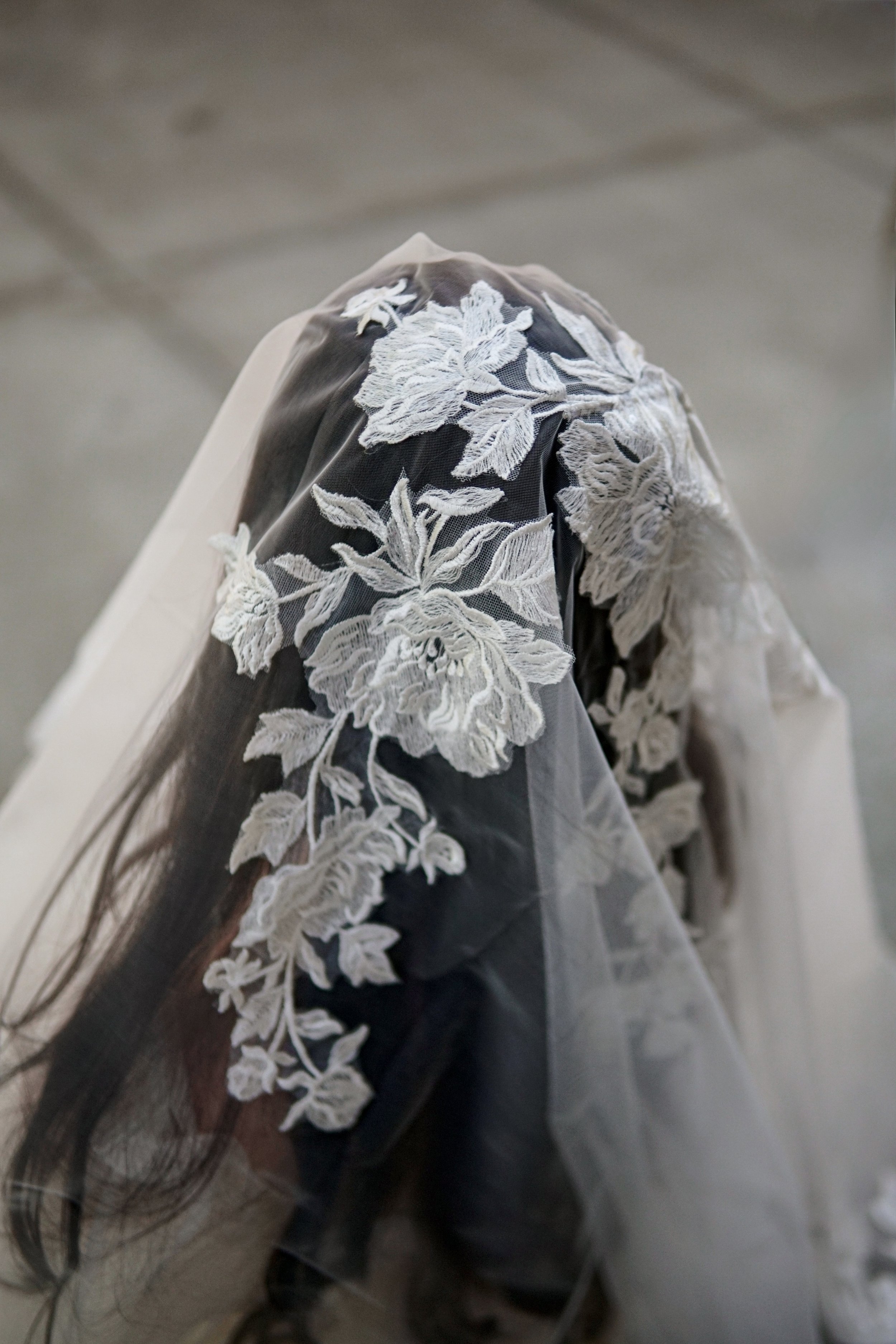 Close picture of the floral lace veil on  the entire head area with mix of large and small flowers and branches
