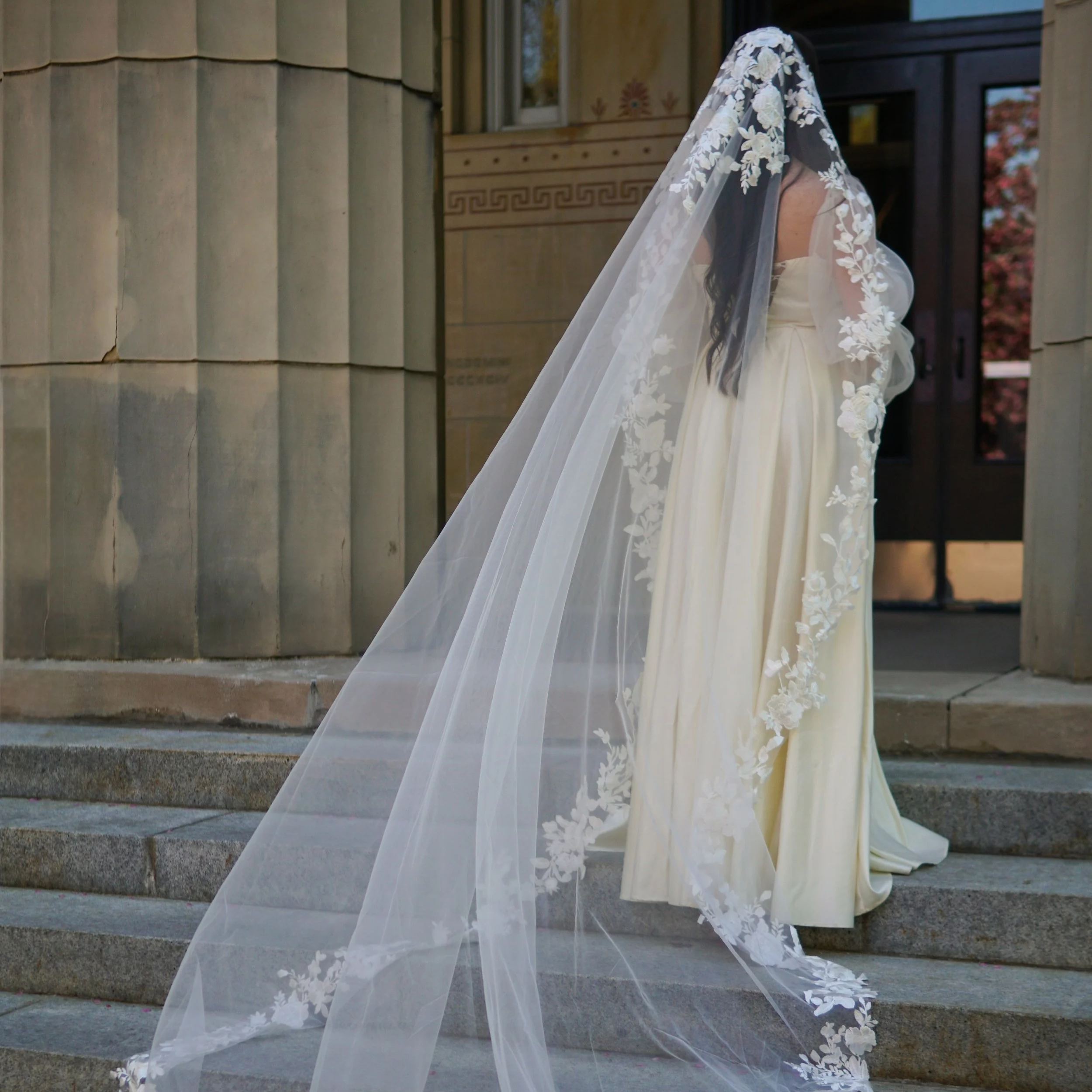 Bride wearing a full lace mantilla floral lace veil with mix of small and bigger flowers