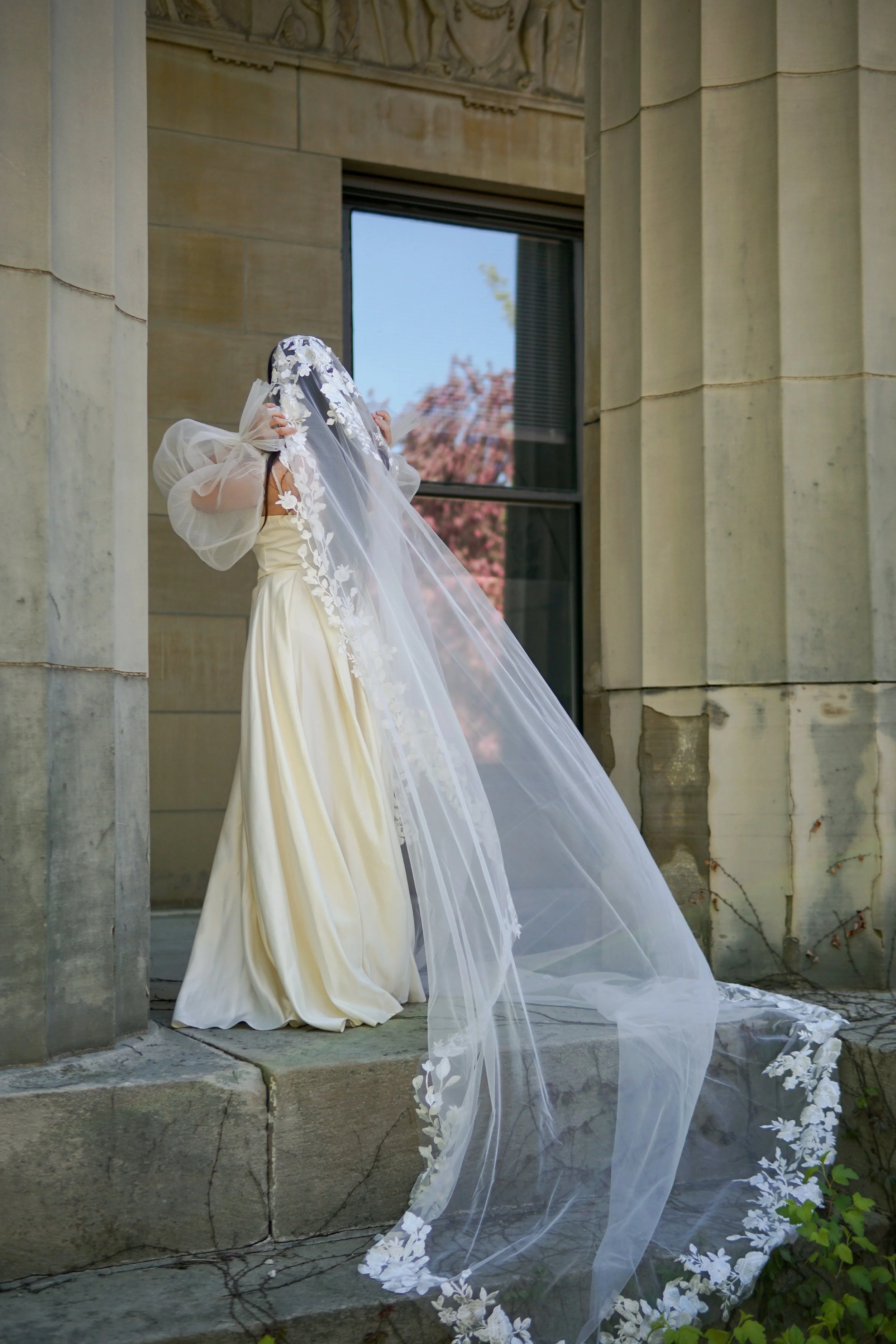 Bride wearing a full lace mantilla floral lace veil with mix of small and bigger flowers