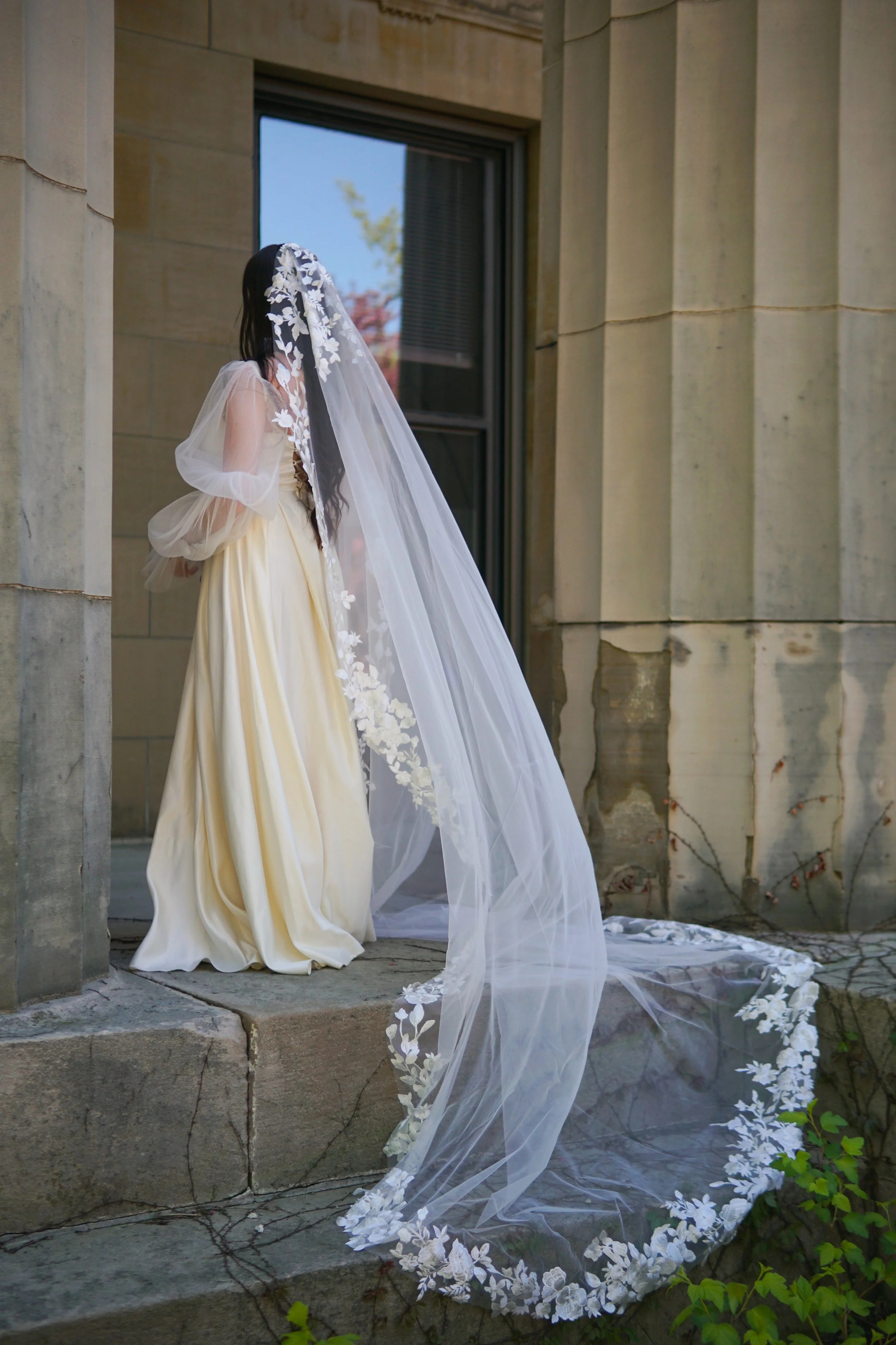 Bride wearing a full lace mantilla floral lace veil with mix of small and bigger flowers
