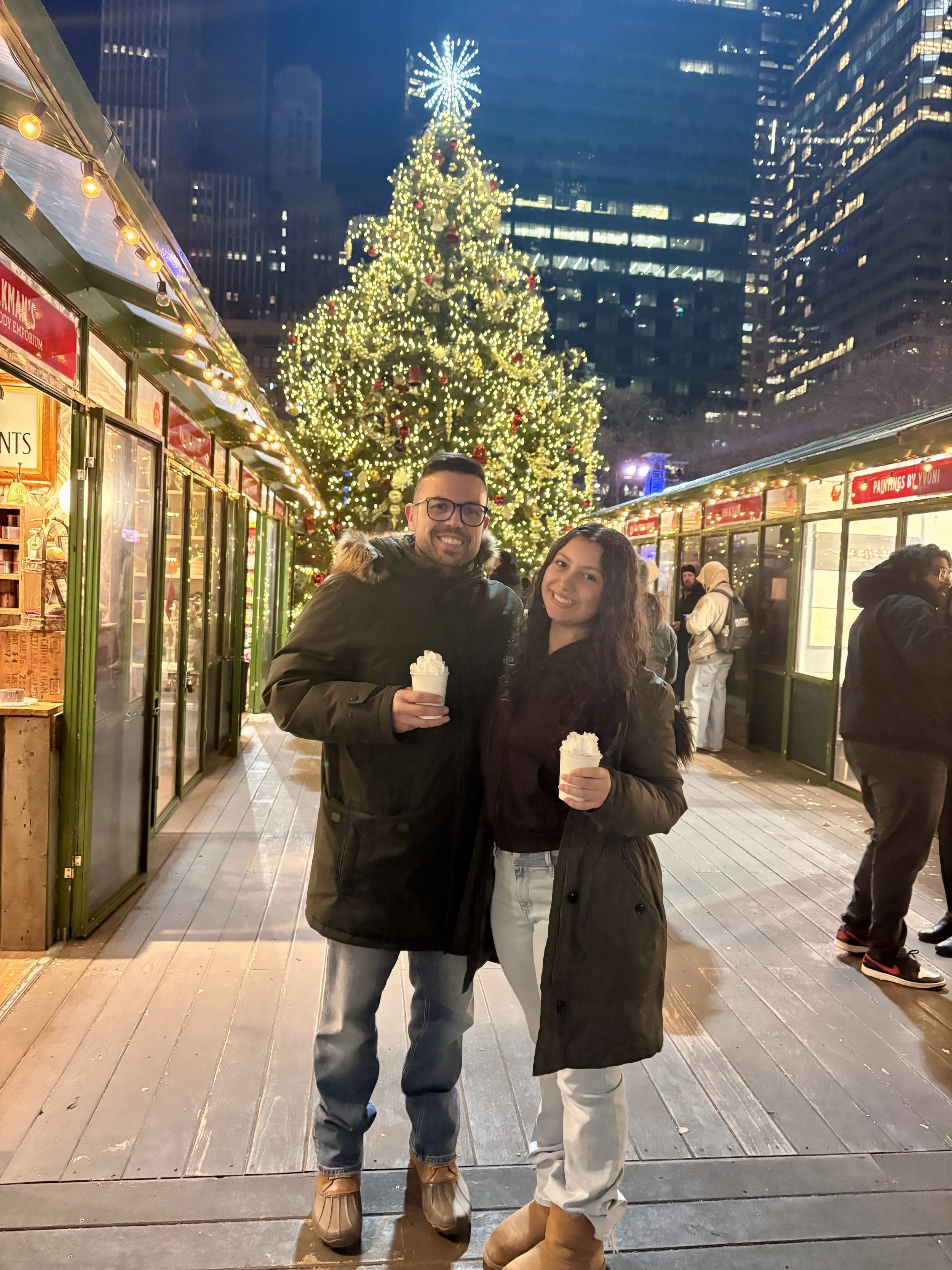 Miguel from Blue Zone Health and Wellness stands in front of a Christmas Tree with his daughter