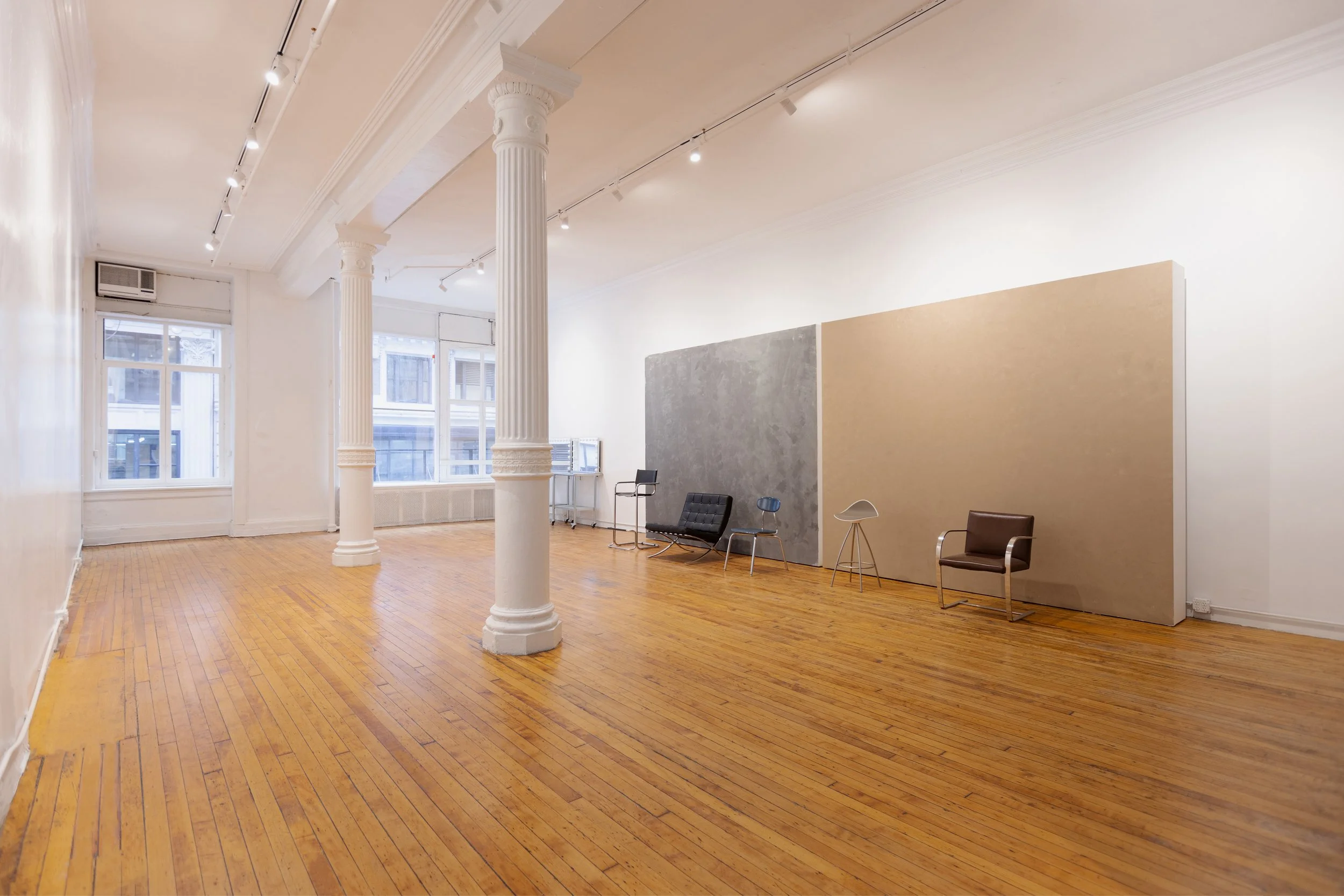 Midtown Manhattan loft space with Roman columns, white gallery walls, and open layout used for event or exhibition.