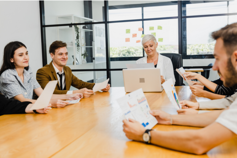 Employees in a meeting demonstrating behavioural skills through communication, shared decision making, and collaboration.