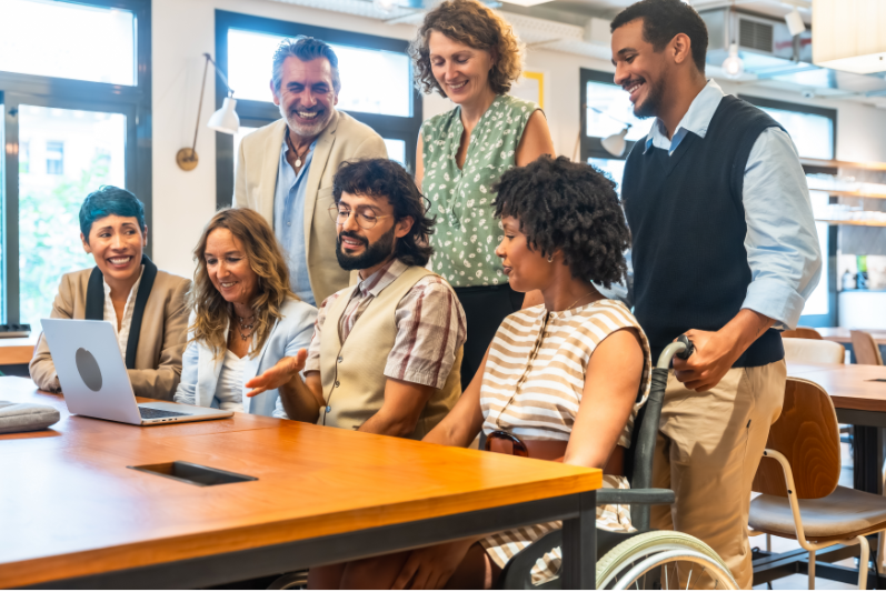 Diverse workplace team discussing work together, representing shared responsibility and collaboration.