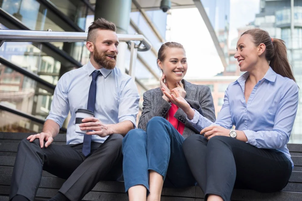 Sidestream UK’s team engaging in collaborative discussion outdoors, emphasizing the importance of team interaction and communication as part of building a high-performance culture in organisations.