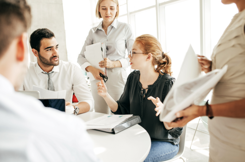 Team collaborating and discussing next steps in a work meeting.