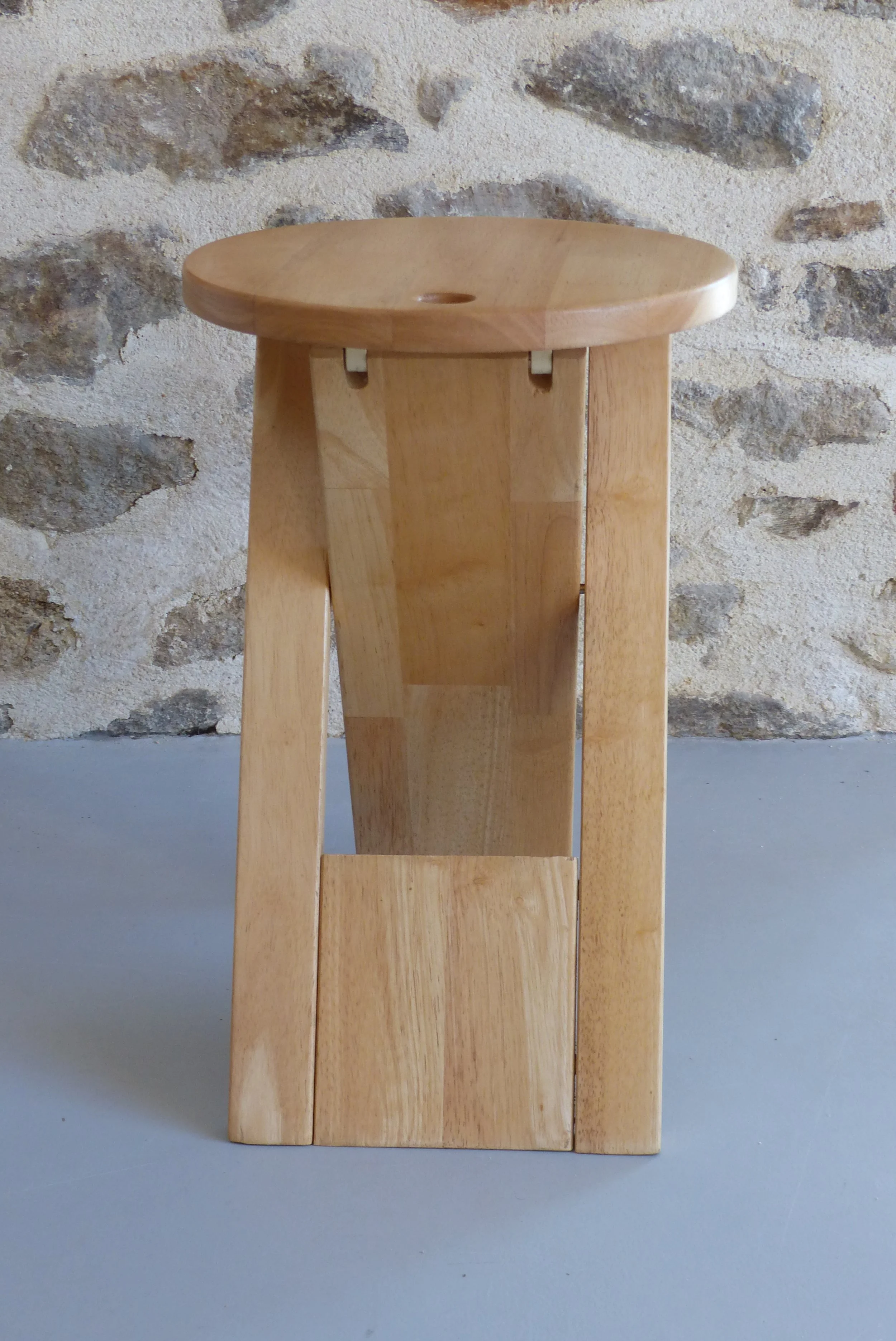Tabouret pliant en bois exotique clair massif lamellé-collé. Dans l’esprit du modèle “Suzy Stool” (1984) dessiné par Adrian Reed