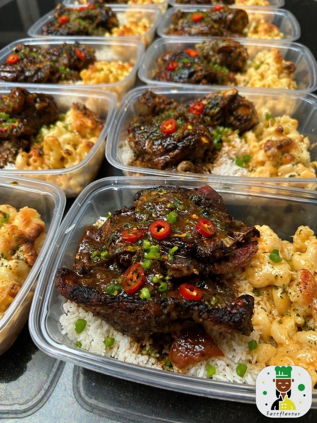 Containers of rice topped with grilled meat and garnished with sliced red chili peppers and green chopped scallions.