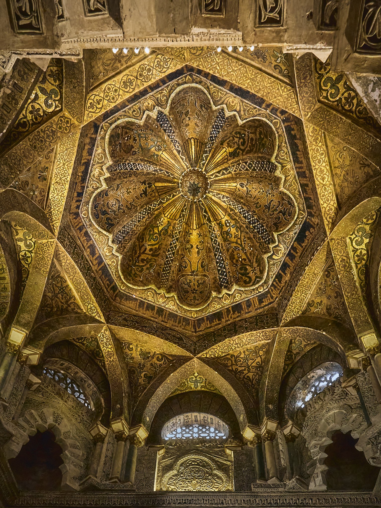 Techo decorado con mosaicos y diseños dorados en la bóveda de una iglesia o templo antiguo.