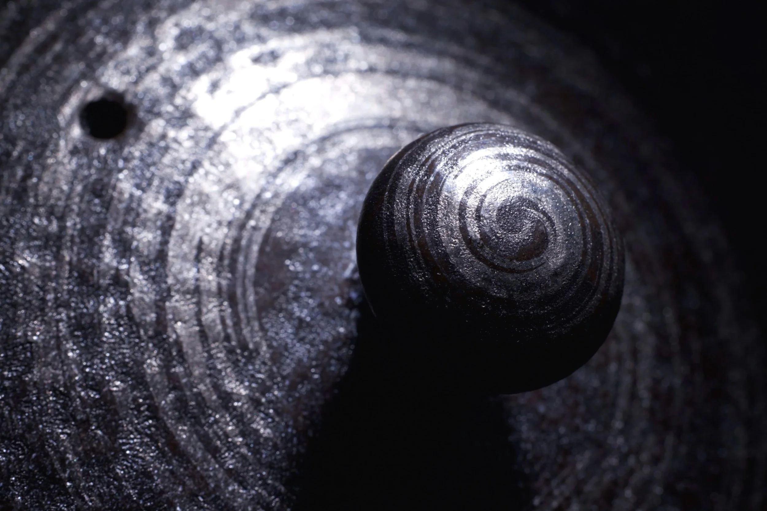 Detail study of ceramic surface and form.

Light reveals the circular traces of making,
highlighting texture, density, and subtle variations in the material.

A close observation of how light interacts with surface —
where structure, shadow, and pres