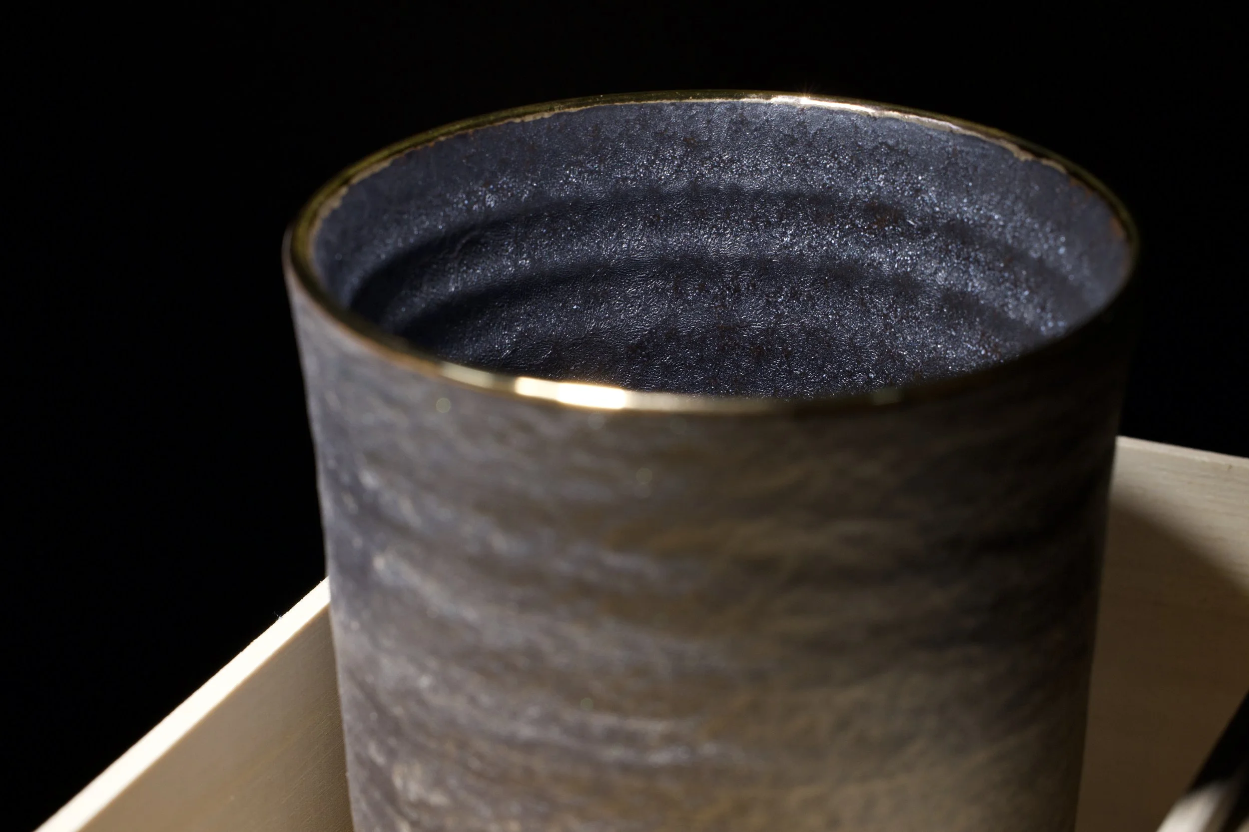 Ceramic vessel product photography highlighting texture and material under controlled lighting.
