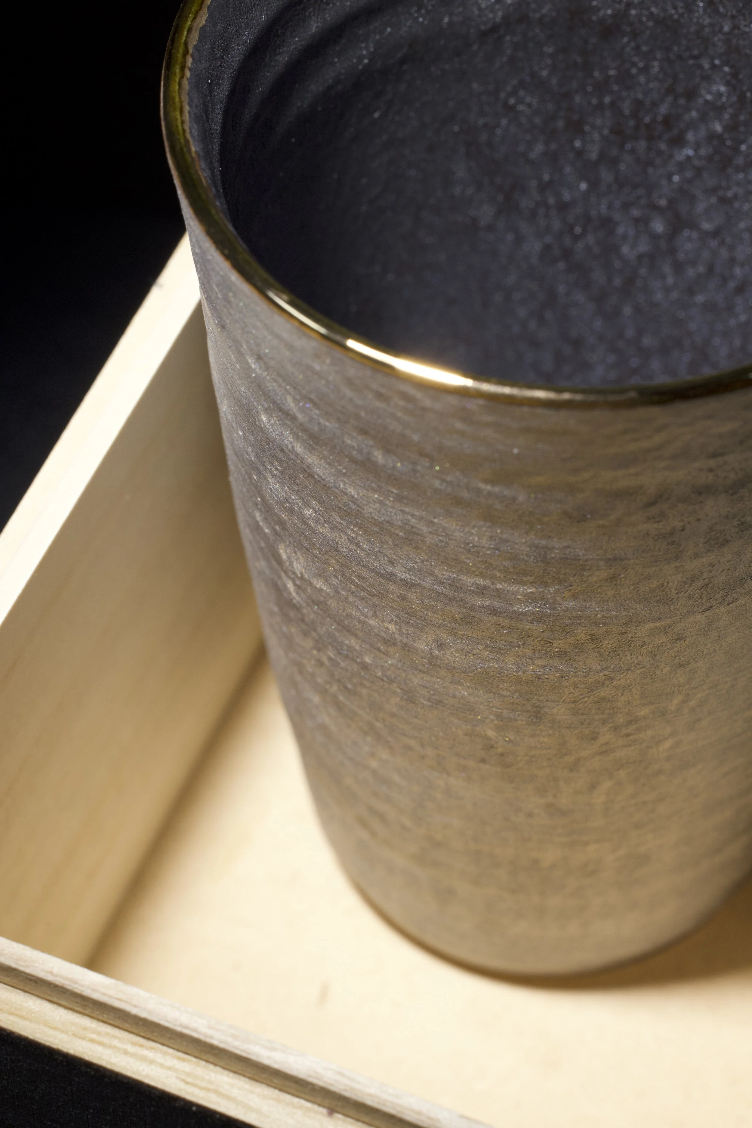 Handcrafted ceramic vessel product photography with dramatic shadow lighting.