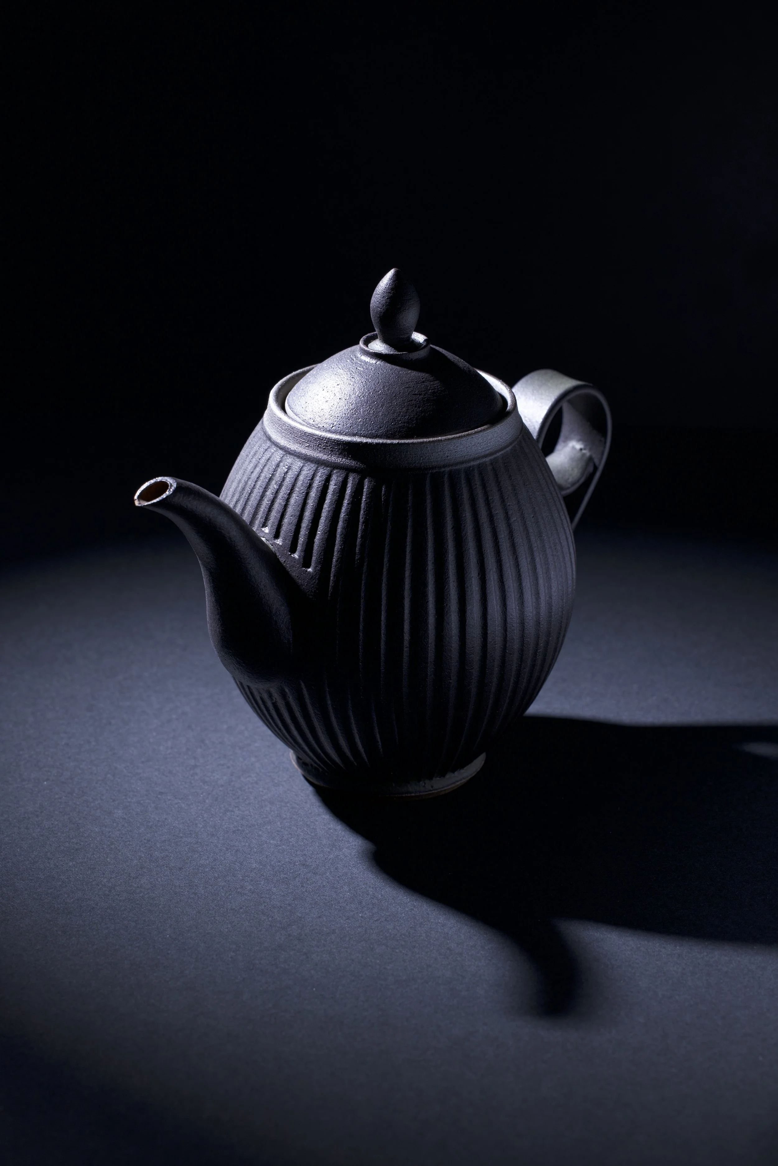 Handcrafted ceramic teapot product photography highlighting texture and form.

