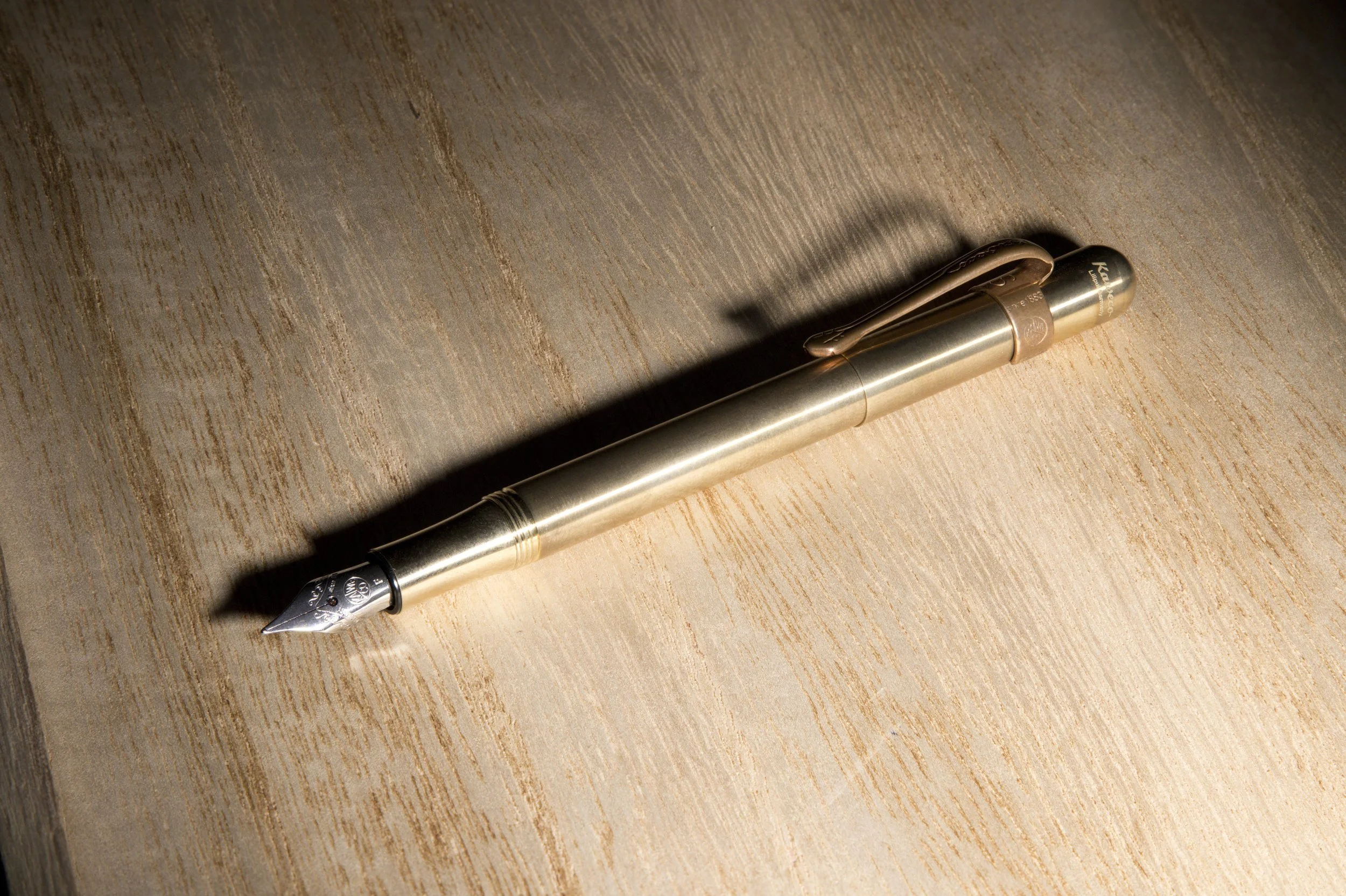 Luxury fountain pen commercial product photography on wood surface.