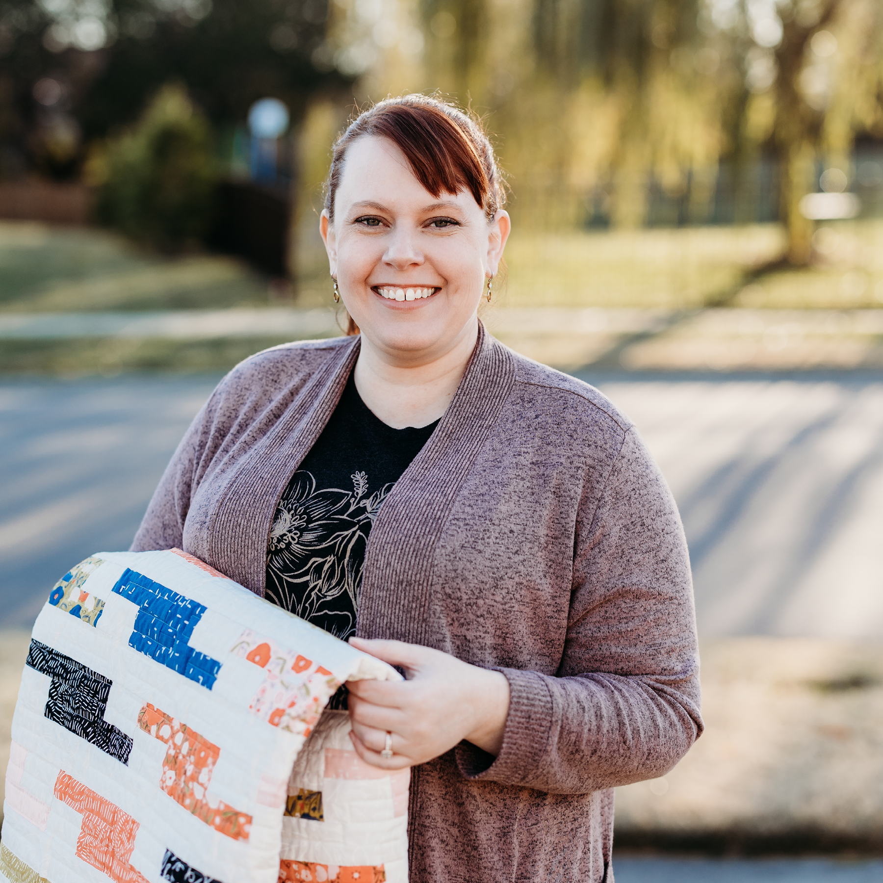 Jennifer Walters outside holding Aspiration quilt - Jennifer Walters.png