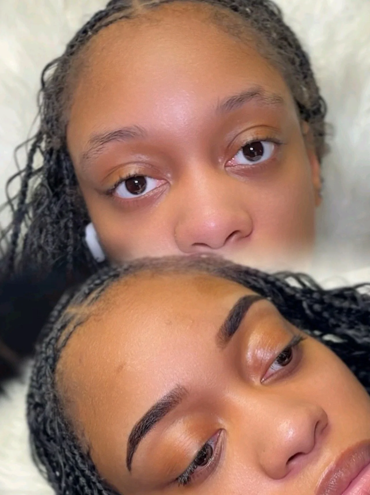 Close-up of two women lying close together with their faces partially visible, showing their eyes, eyebrows, and foreheads.