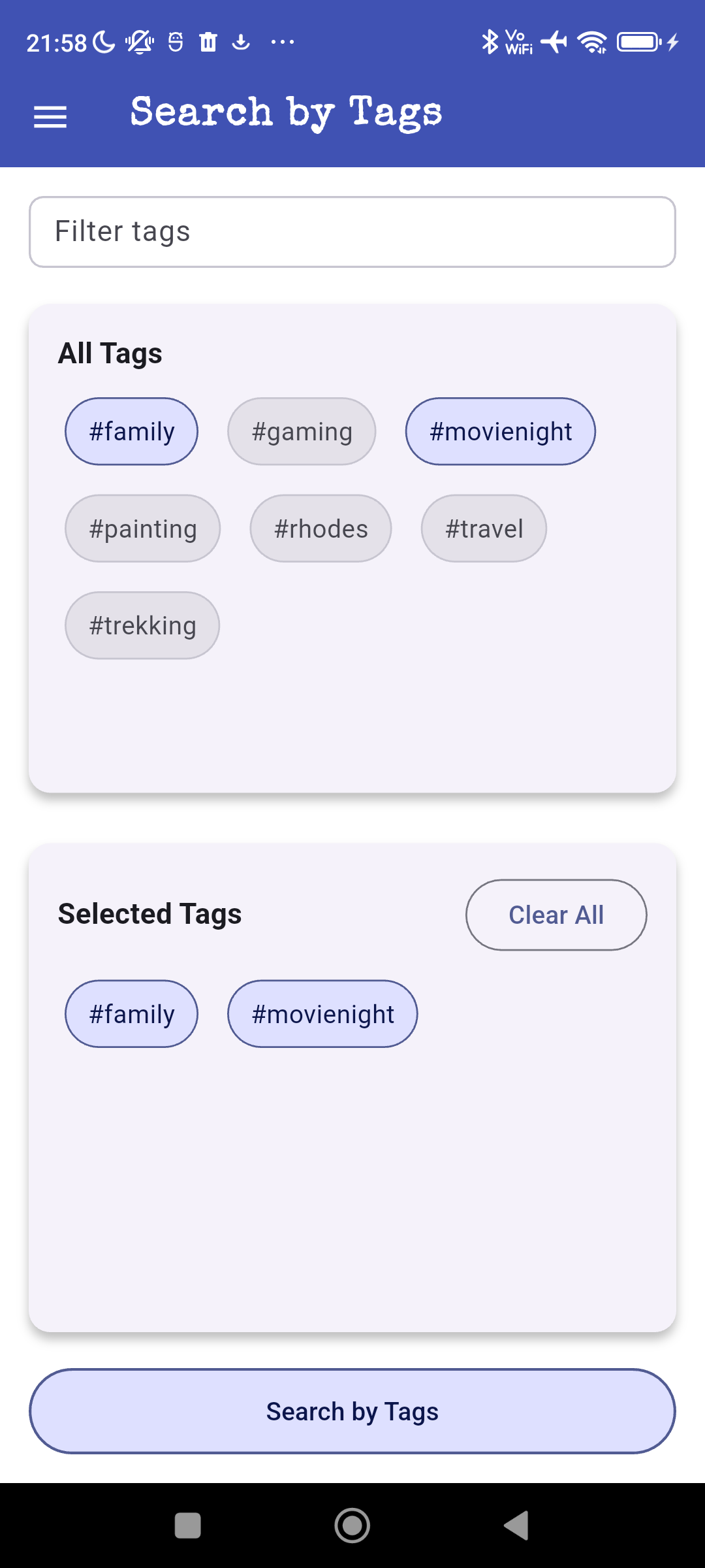 Mobile app screen displaying a 'Search by Tags' page with options to filter tags such as #family, #gaming, #movienight, #painting, #rhodes, #travel, and #trekking. Selected tags '#family' and '#movienight' are shown below with a 'Clear All' button and a search button at the bottom.