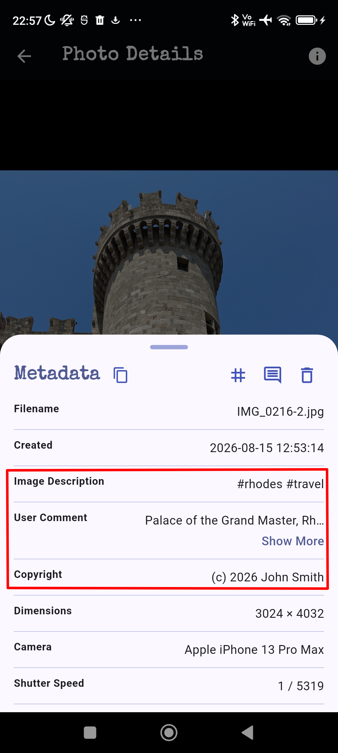 Photo of a stone tower against a clear blue sky, with the metadata indicating a photo taken at the Palace of the Grand Master in Rhodes, Greece.