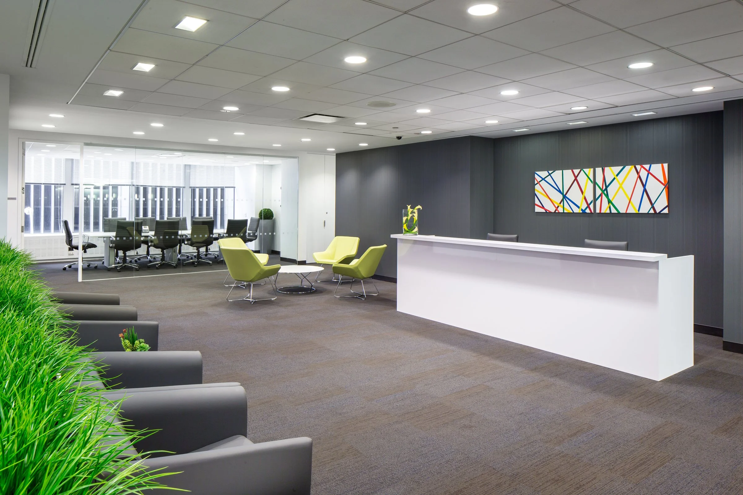 Office space lobby in Midtown Manhattan with a reception desk, lounge seating, and a glass-walled window conference room