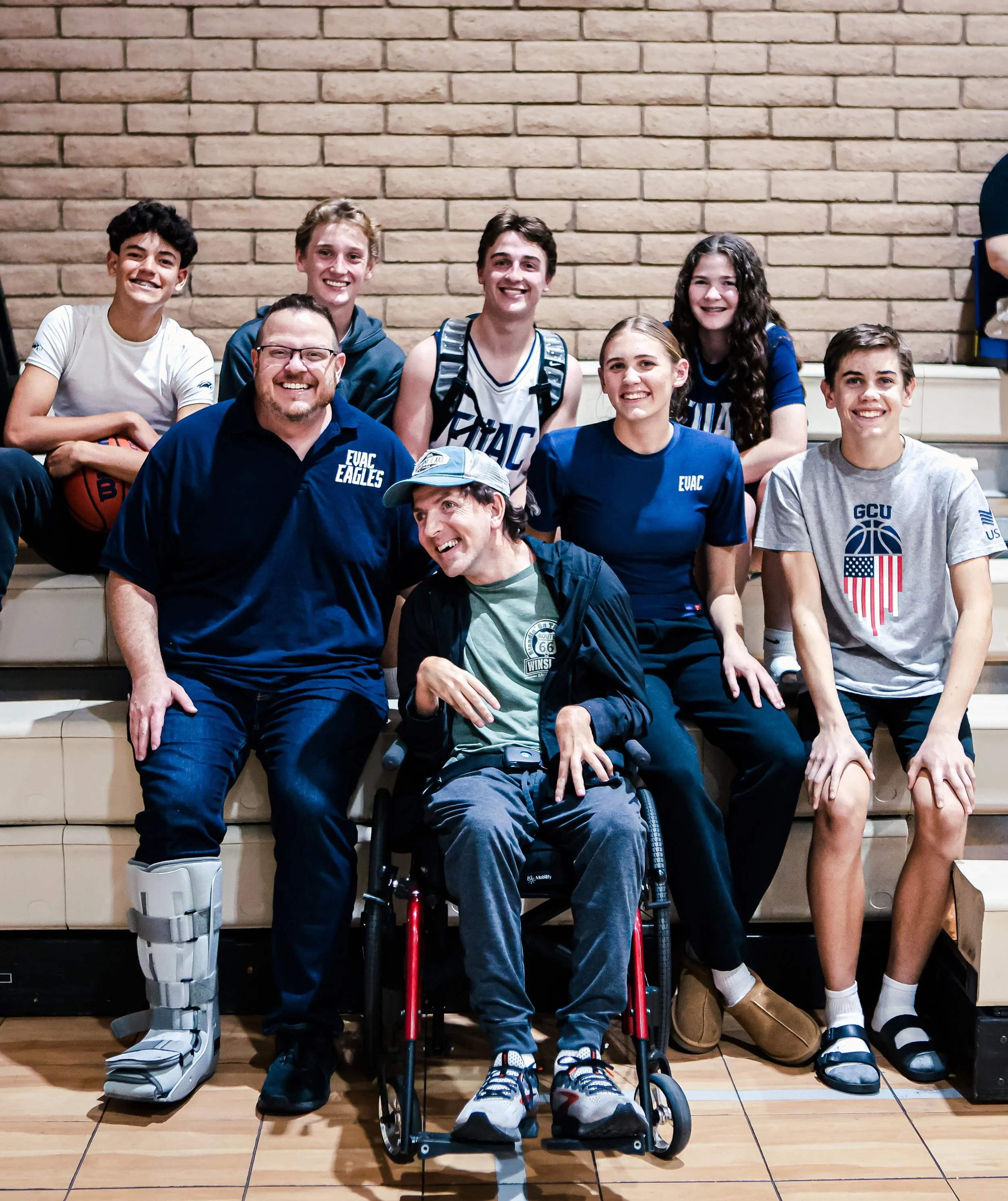 Picture of Daniel with a group of EVAC students at a game with everyone smiling