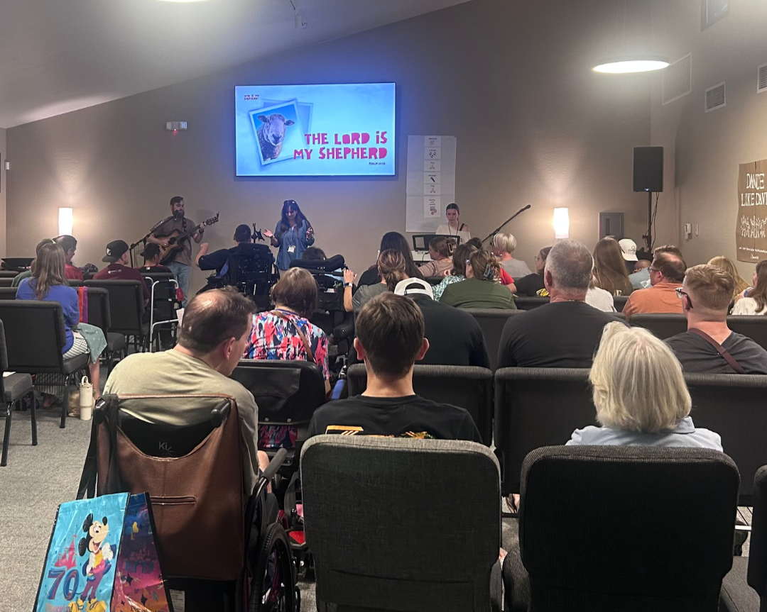 Image of people in a room sitting looking to the front of the room