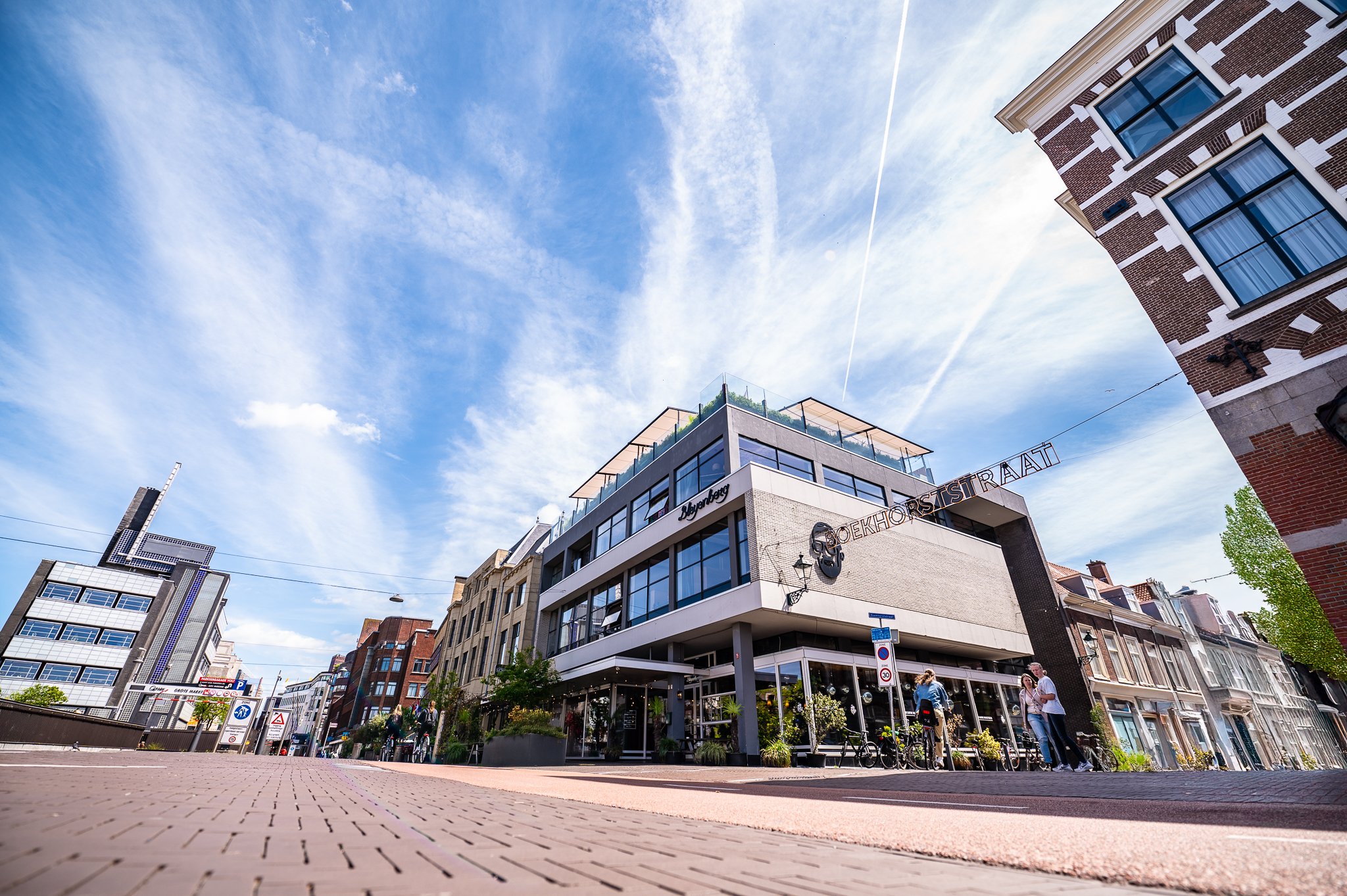 Groep mensen die lachen en plezier maken onder kleurrijke avondverlichting.