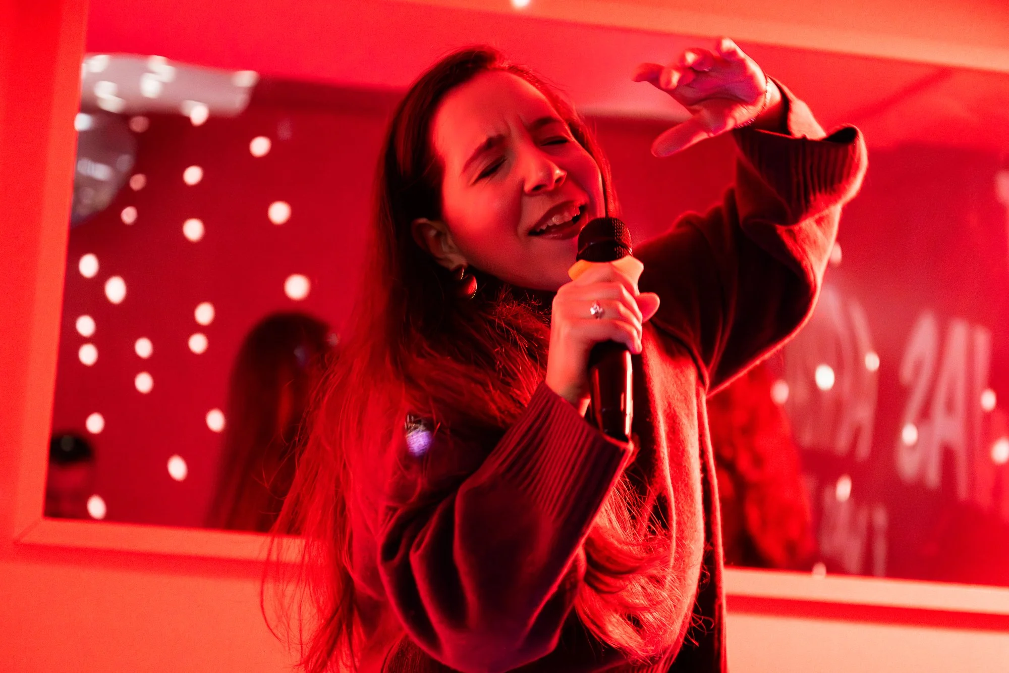 Een vrouw die geniet van het meezingen van haar favoriete karaoke-nummers bij BLÊR karaoke in het centrum van Den Haag
