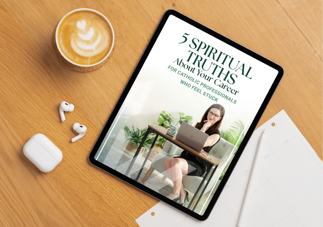 A tablet displaying a book cover titled "5 Spiritual Truths About Your Career for Catholic Professionals Who Feel Stuck", with a woman sitting at a desk with a laptop, surrounded by plants. There is a cup of coffee with latte art, wireless earbuds, a charging case for earbuds, a pen, and some white papers on a wooden desk.