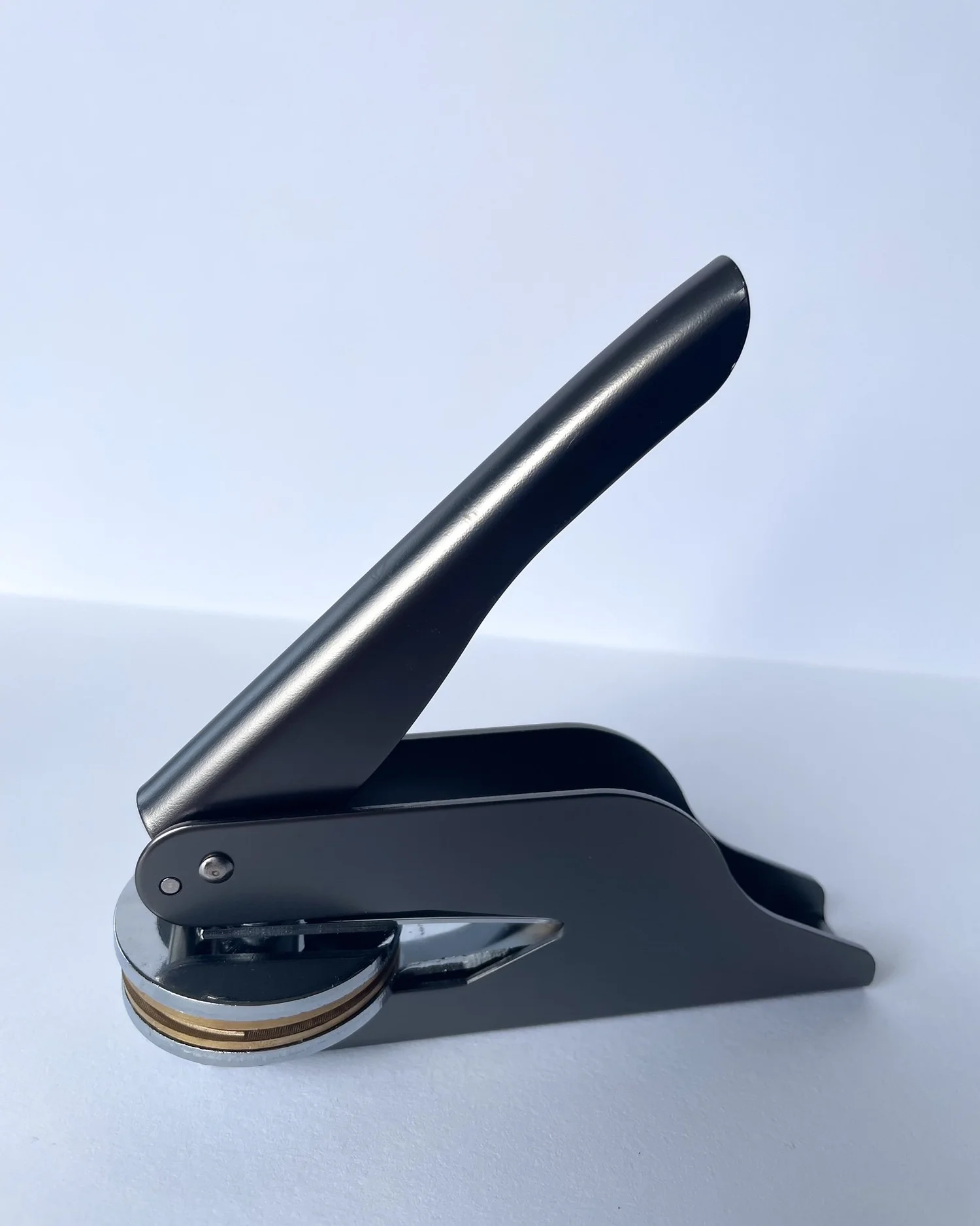 Gunmetal embosser side on to camera. Plain white background.