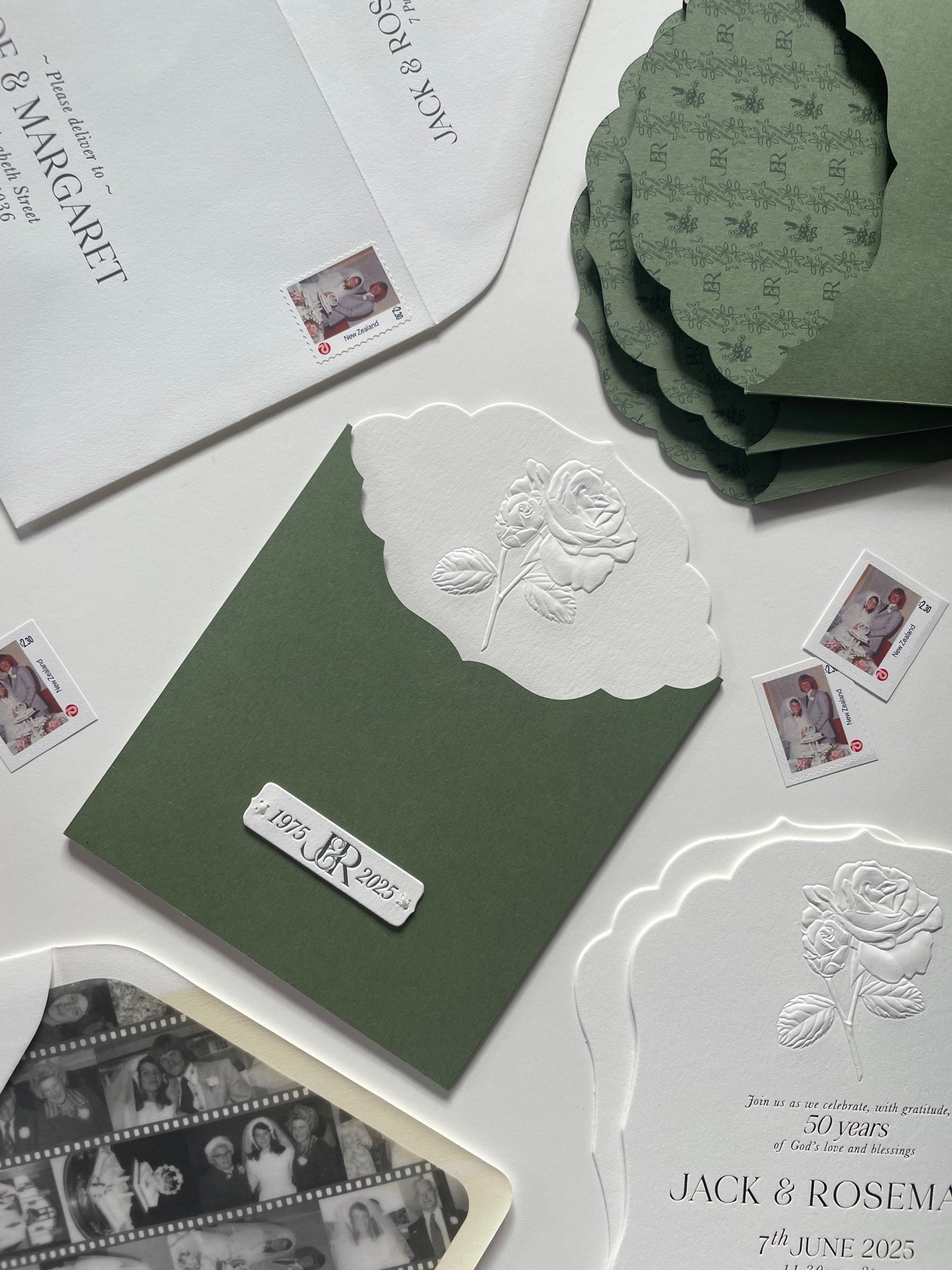 3-piece anniversary celebration invitation set. Envelope featuring custom post stickers and custom liner of black-and-white photos. Invites have scalloped edges and large embossed rose. Invite sits in green sleeve with matching scalloped edge.