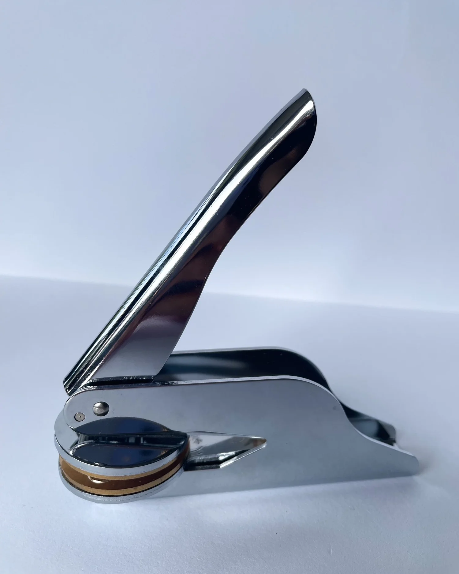 Silver embosser side on to camera. Plain white background.