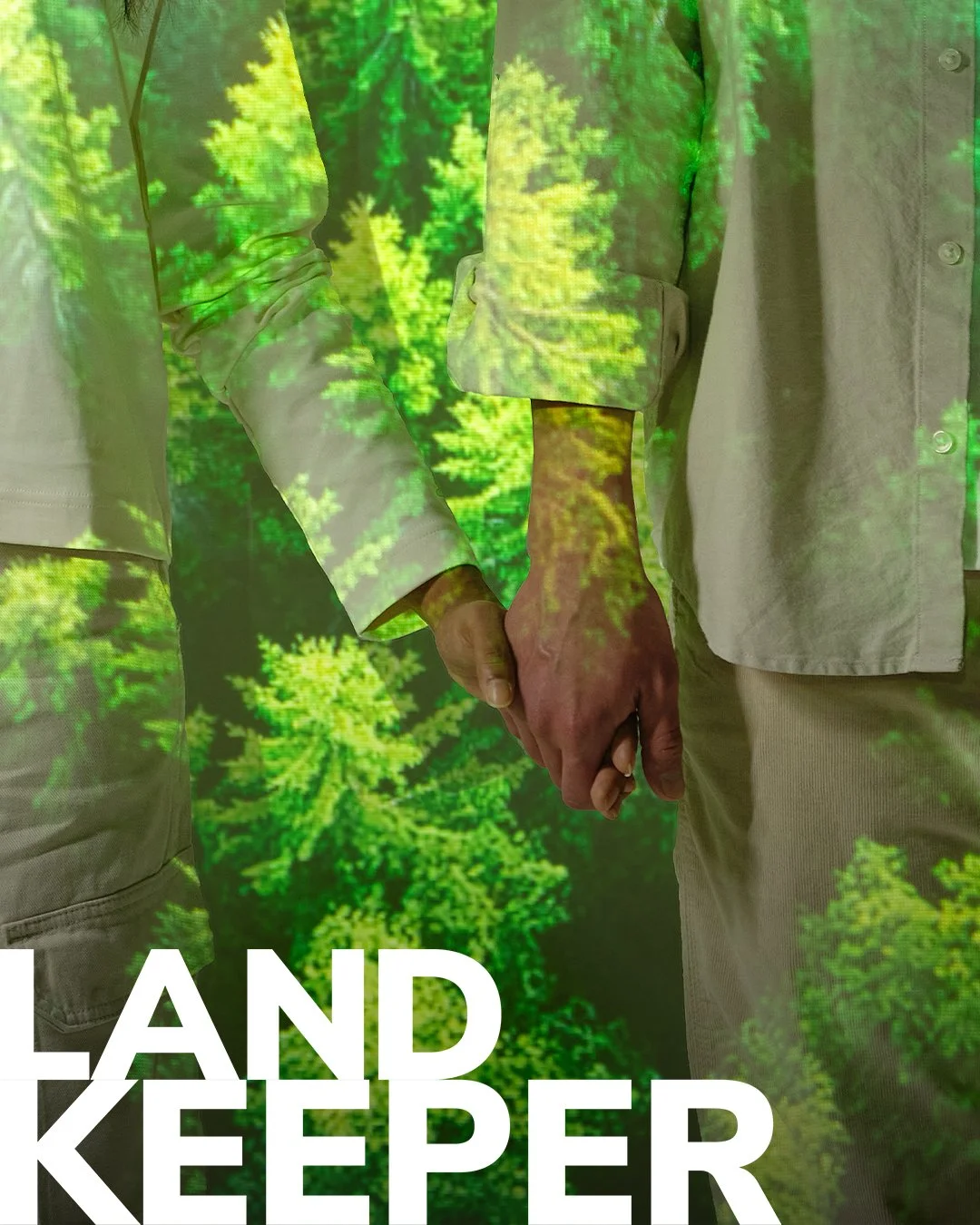 Zwei Personen halten sich an den Händen, im Hintergrund und auf ihrer Kleidung ist ein projiziertes Bild von einem grünen Wald zu sehen.