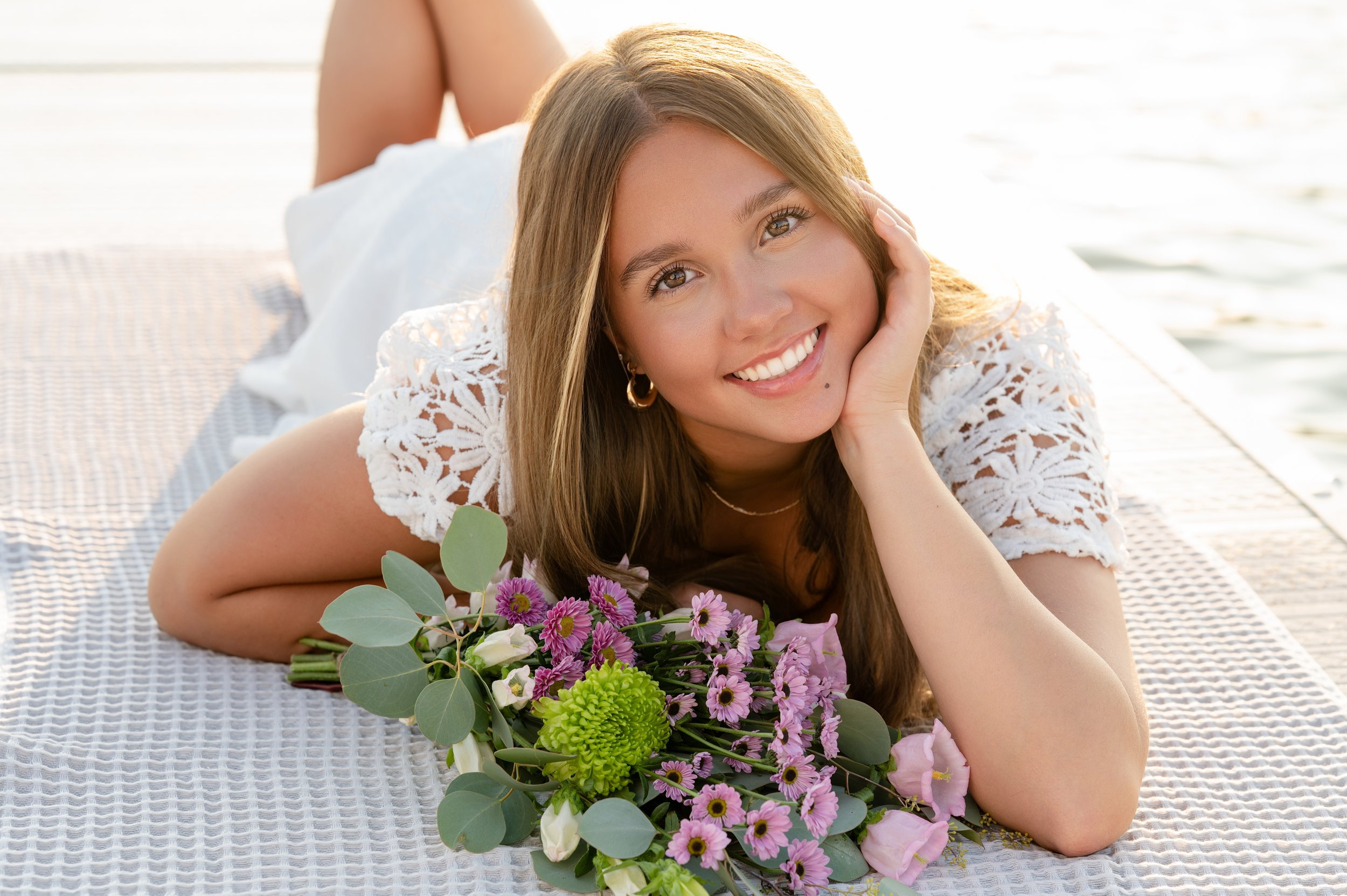 Senior girl posing by water on a dock during senior portrait session in Janesville, WI