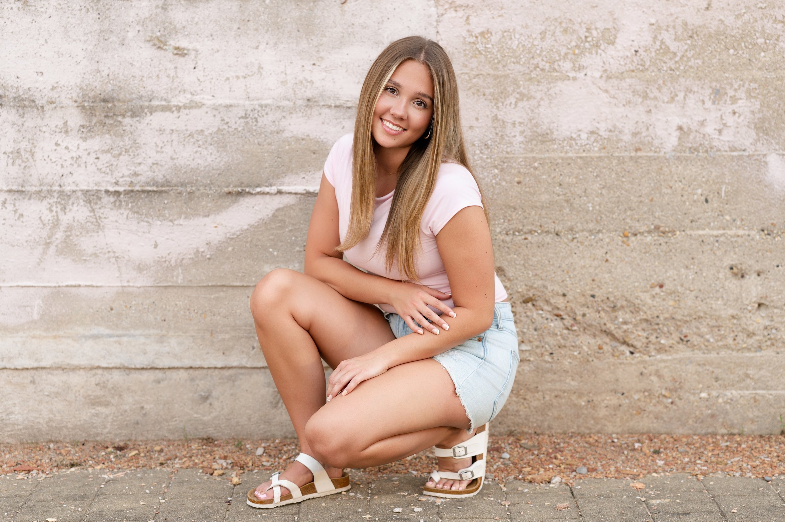 High school senior girl smiling during outdoor senior portrait session in Janesville, WI