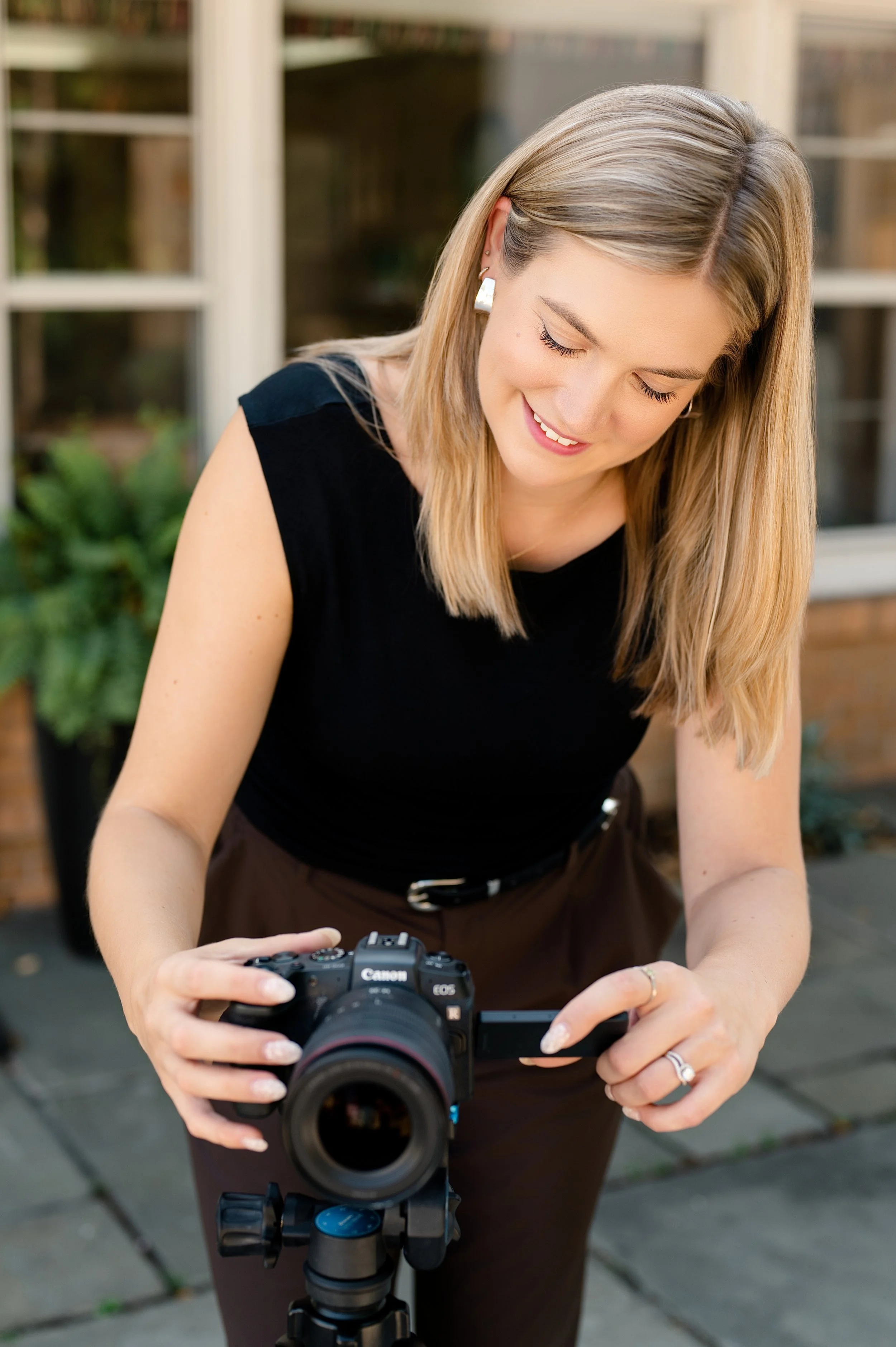 branding photoshoot of a photographer adjusting her camera outside on a tripod