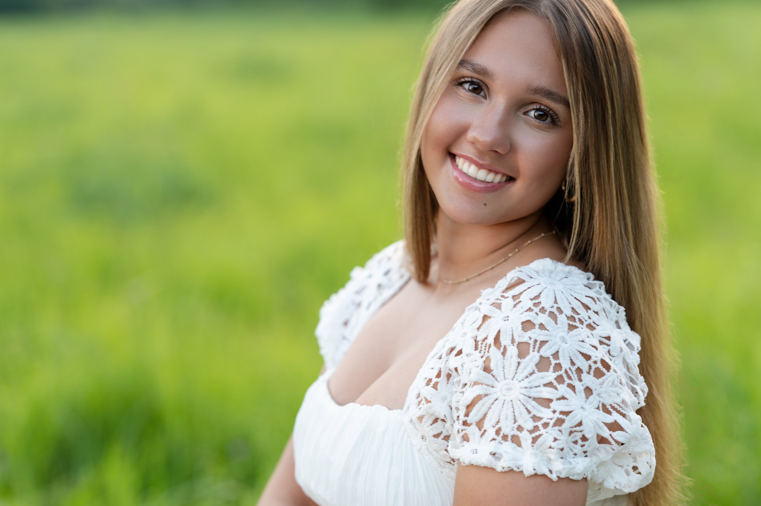 Senior girl smiling during outdoor meadow senior portrait session by Ice Age Trail in Janesville, WI