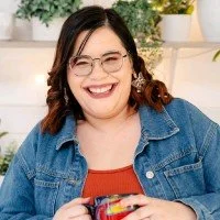 Samantha Eck is smiling and holding a coffee mug