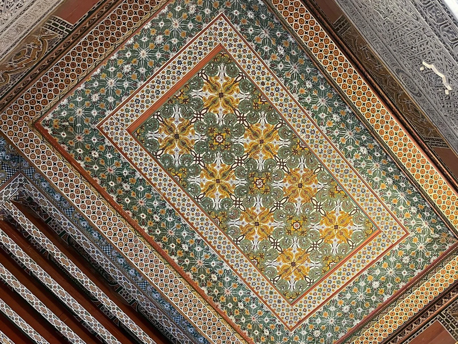 Colourful and intricate handmade tiles on the ceiling of a riad in Morocco