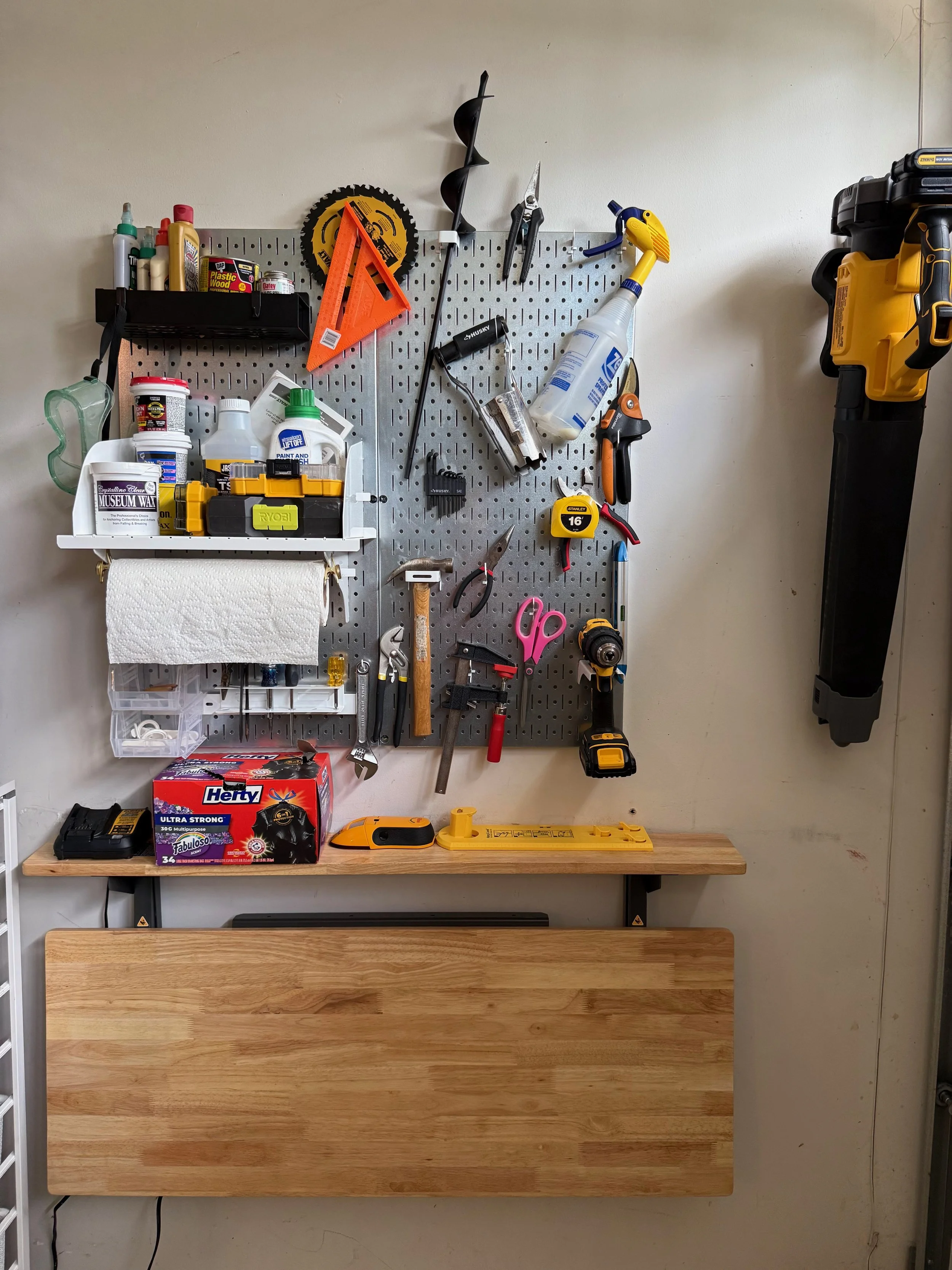 Professionally organized garage with collapsible workbench and pegboard tool storage in an Arlington, VA,  home