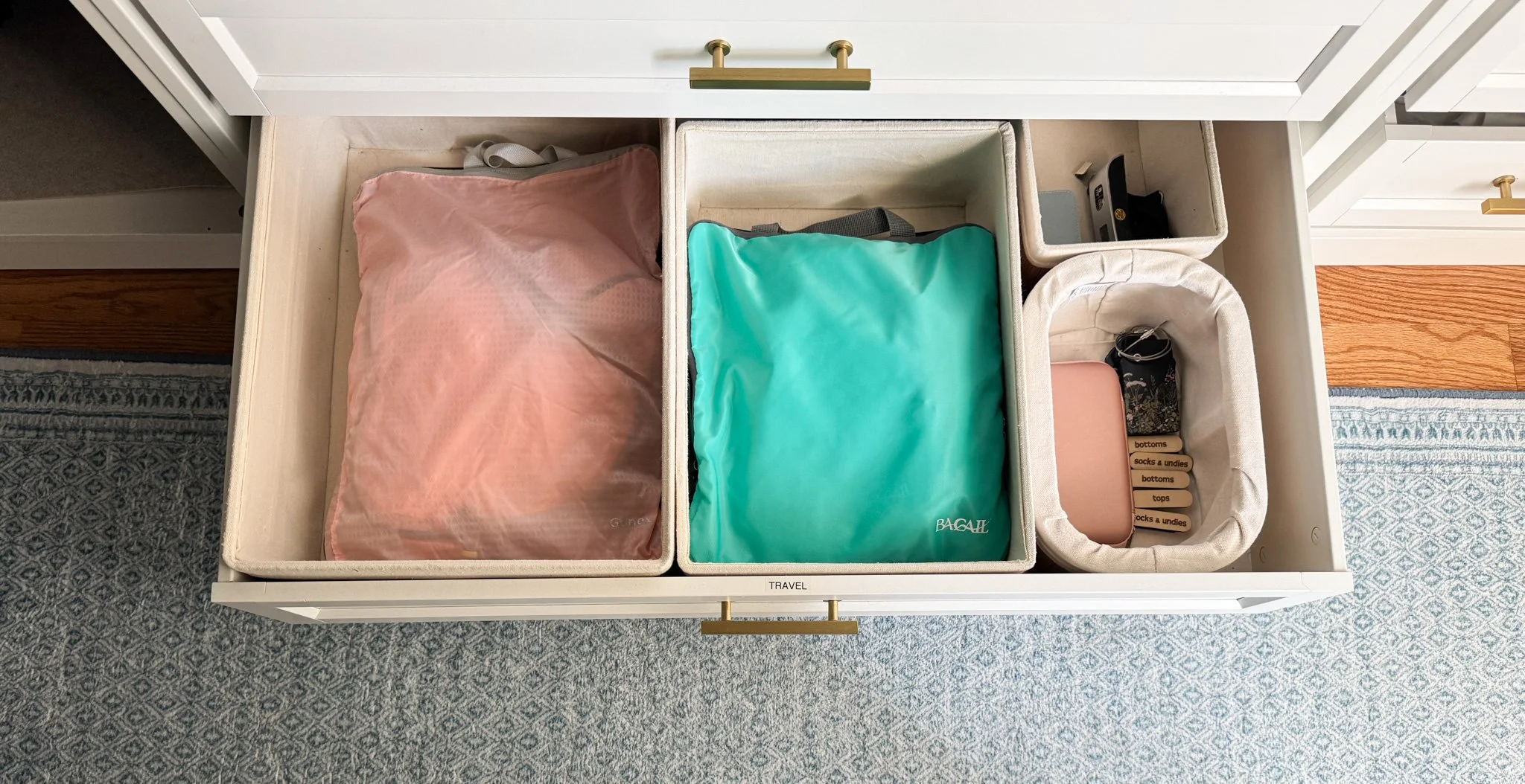 Organized travel drawer in a closet with packing cubes, charger bags, and travel essentials designed for fast packing and easy post-trip resets.