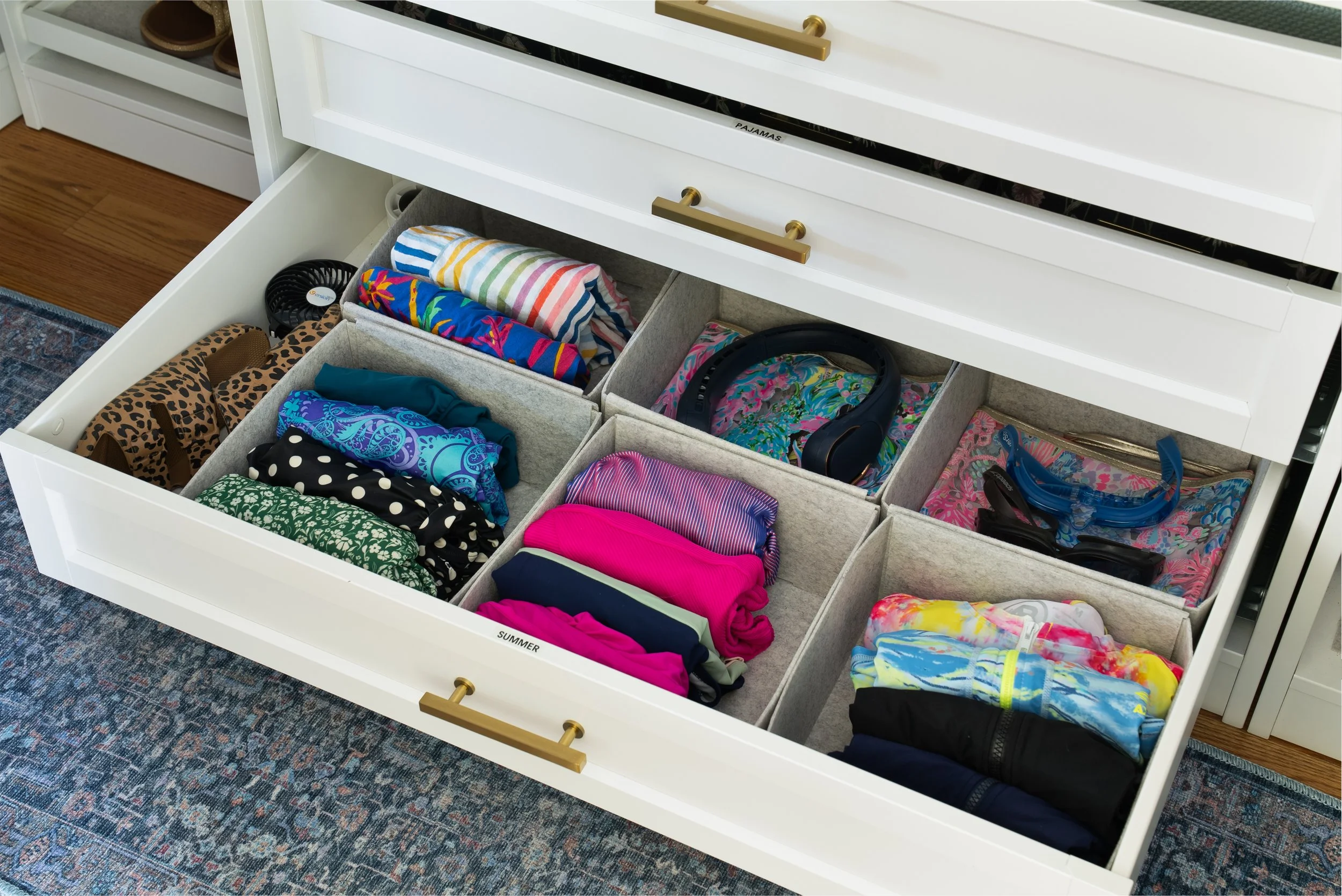 A drawer in a woman's closet holding summer apparel.