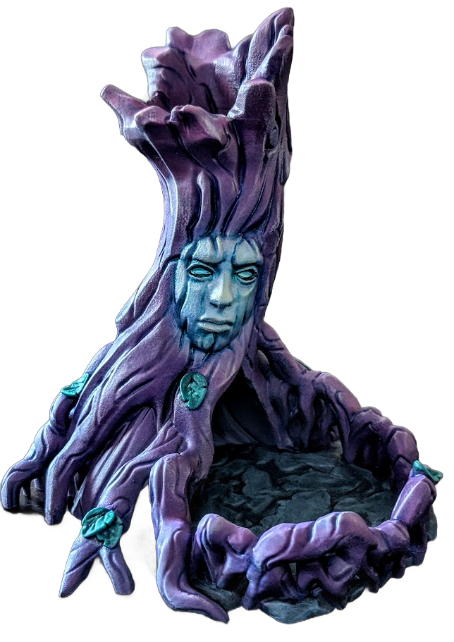 A purple sculpture resembling a tree with a human face embedded in the trunk, with twisted roots forming a seat or hollow at the base.