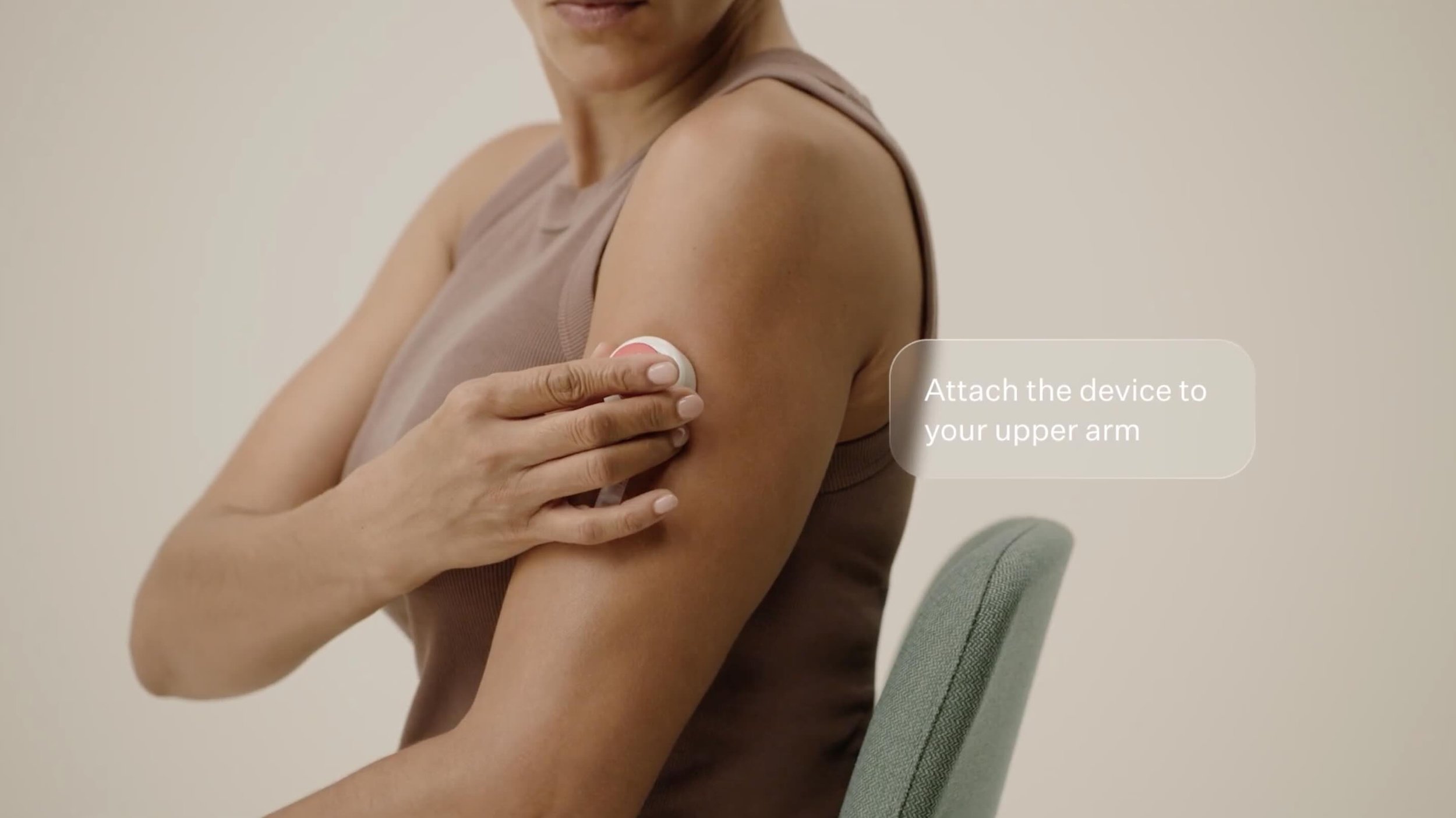 A woman places a biomarker test device onto her arm during a corporate video for Noom.