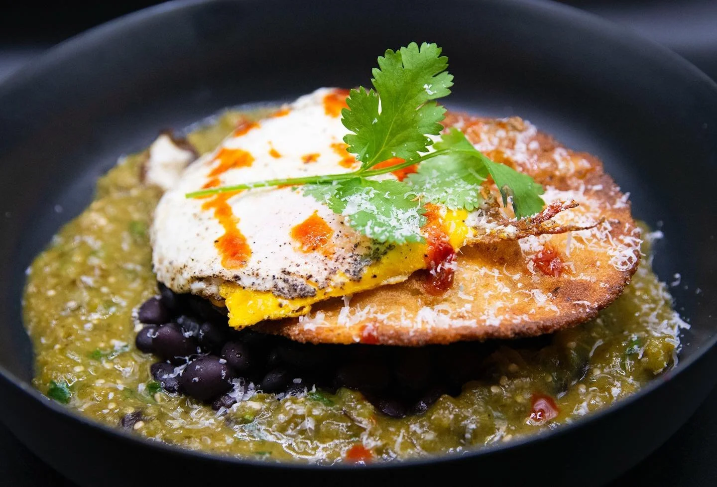 Heavos rancheros 🍳 aka comfort in a bowl 🥰
-
Fresh corn tostada laid on a bed of black beans and salsa verde with a pan fried egg and sriracha. Created by @chefdillon 
-
-
#conamor #conamorfl #masa #maiz #tortilla #masatortilla #whitecorn #heirloom