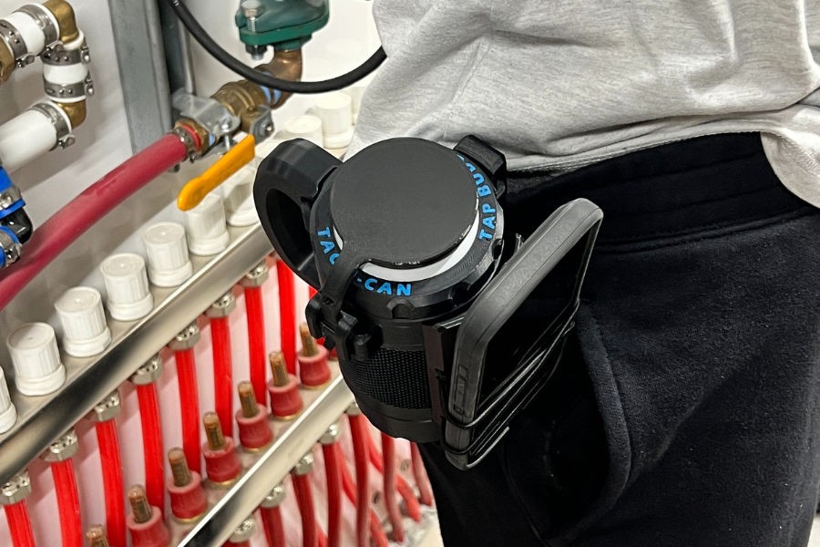 Person wearing black pants has a Tacti-can can coozie attached to their waist with a belt clip. Tacti-can is holding their phone securely with a its Stretcher Clix accessory.