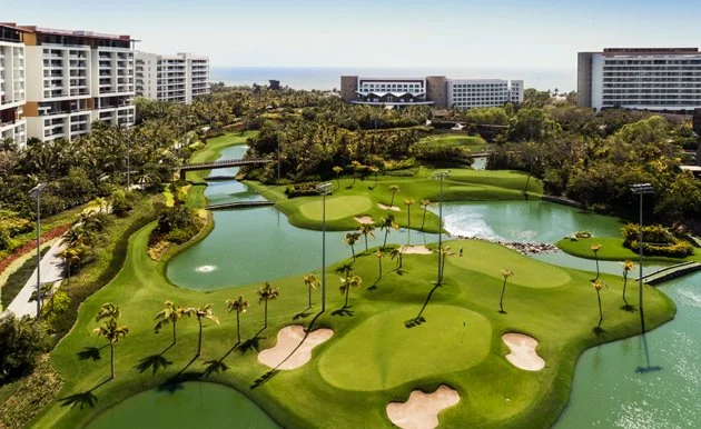 Drone aerial shot of Vidanta Nuevo Vallarta featuring golf course and Grand Luxxe buildings