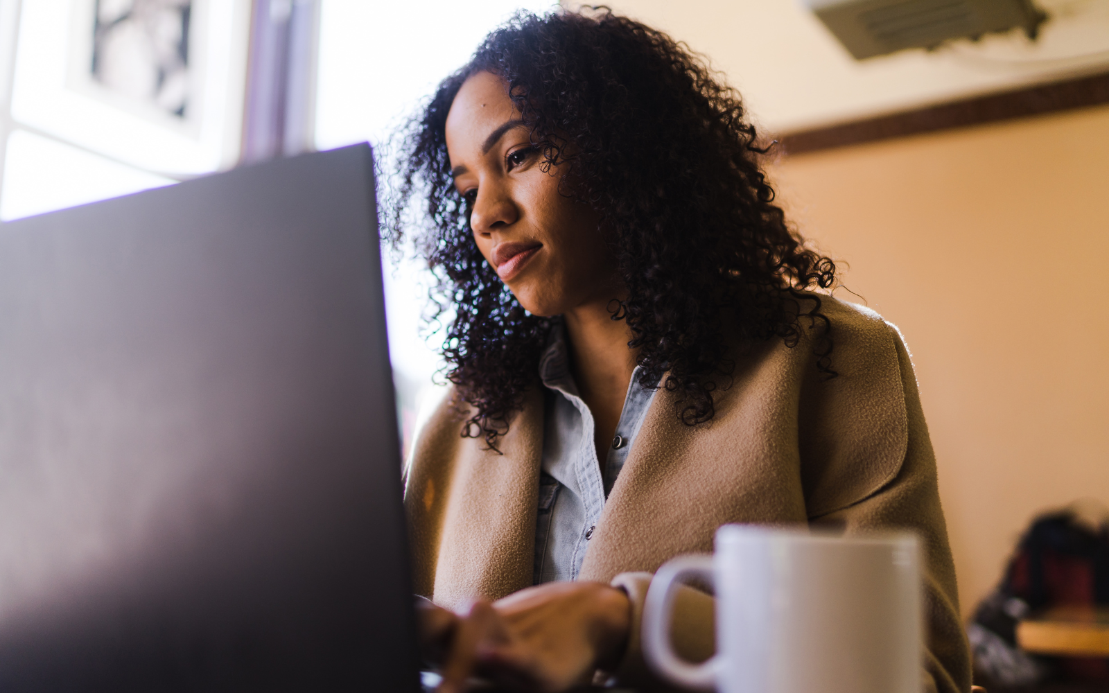 A woman sitting on her laptop at a cafe.