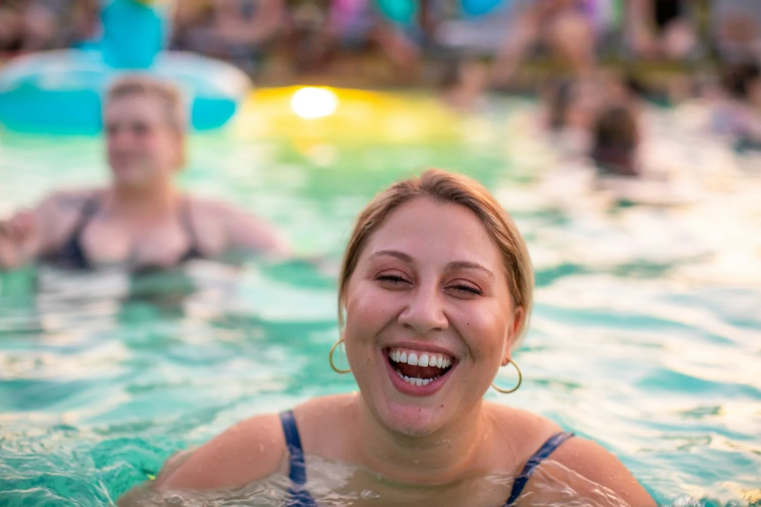 A smiling woman swimming in a pool.