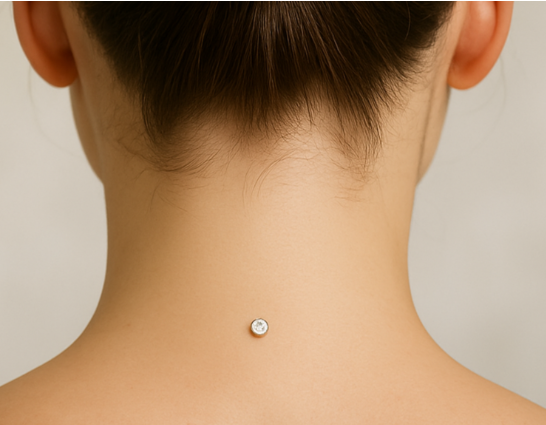 Close-up of a person's neck and back of the head with a small, round, clear gemstone belly button piercing.