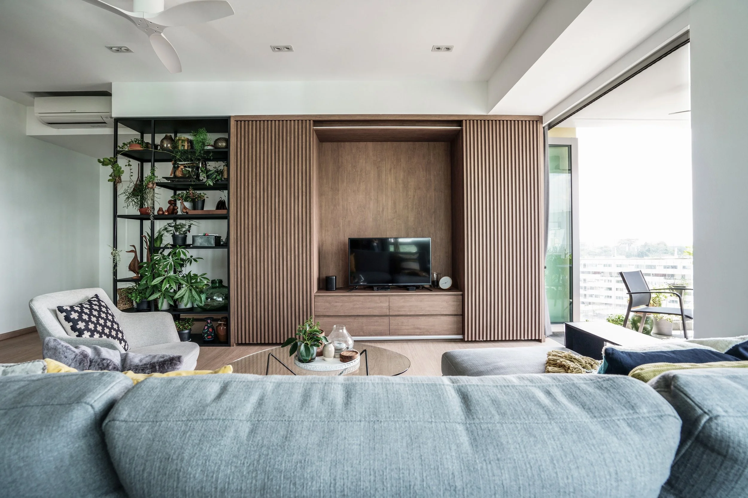 Modern personalized living room interior in Singapore designed by a reputable interior design firm, featuring custom cabinetry, warm lighting, and contemporary finishes.